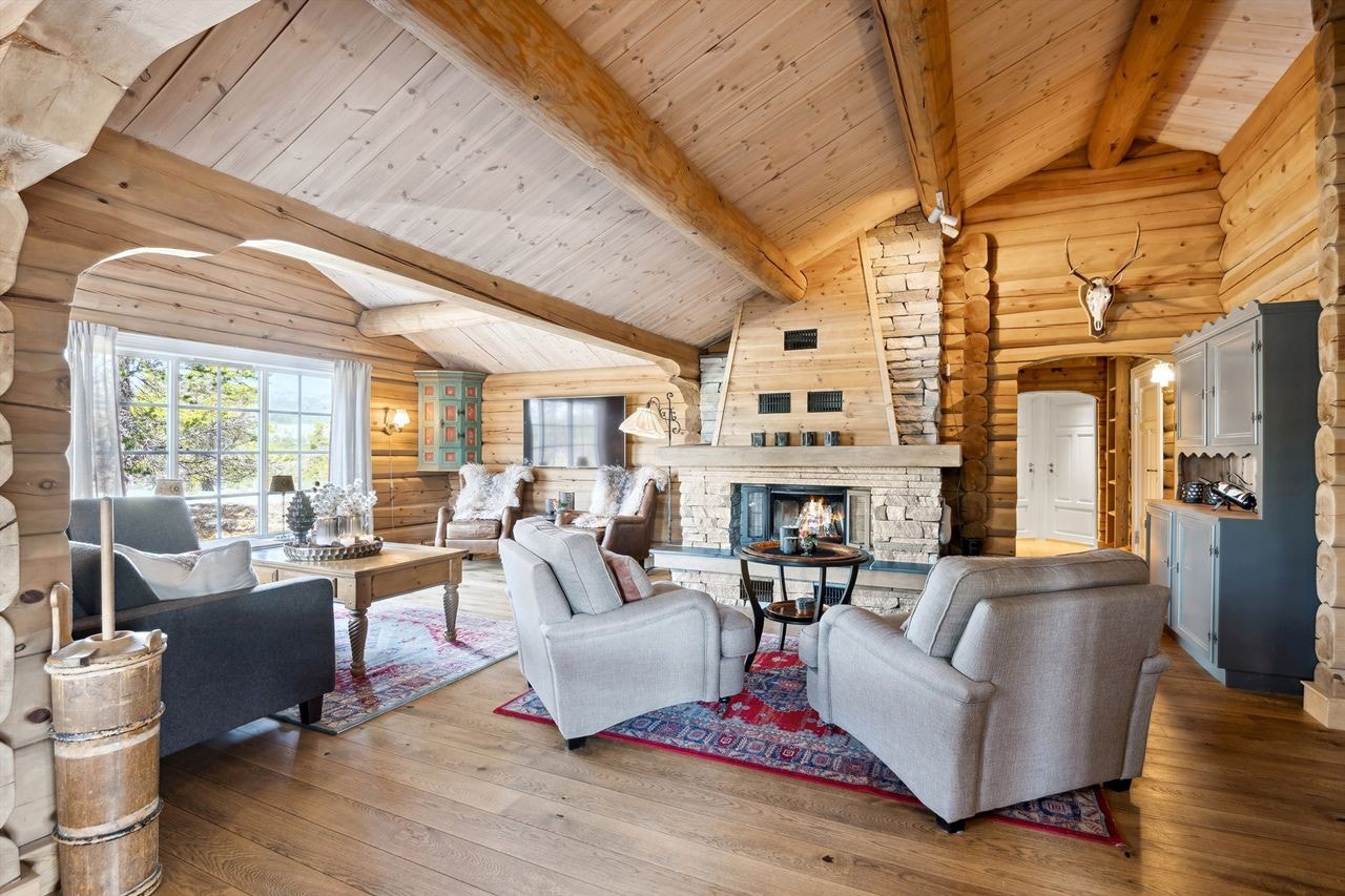 Hytta har ei fantastisk stue der den murte peisen med innsats er som et majestetisk møbel i rommet Galleribilde