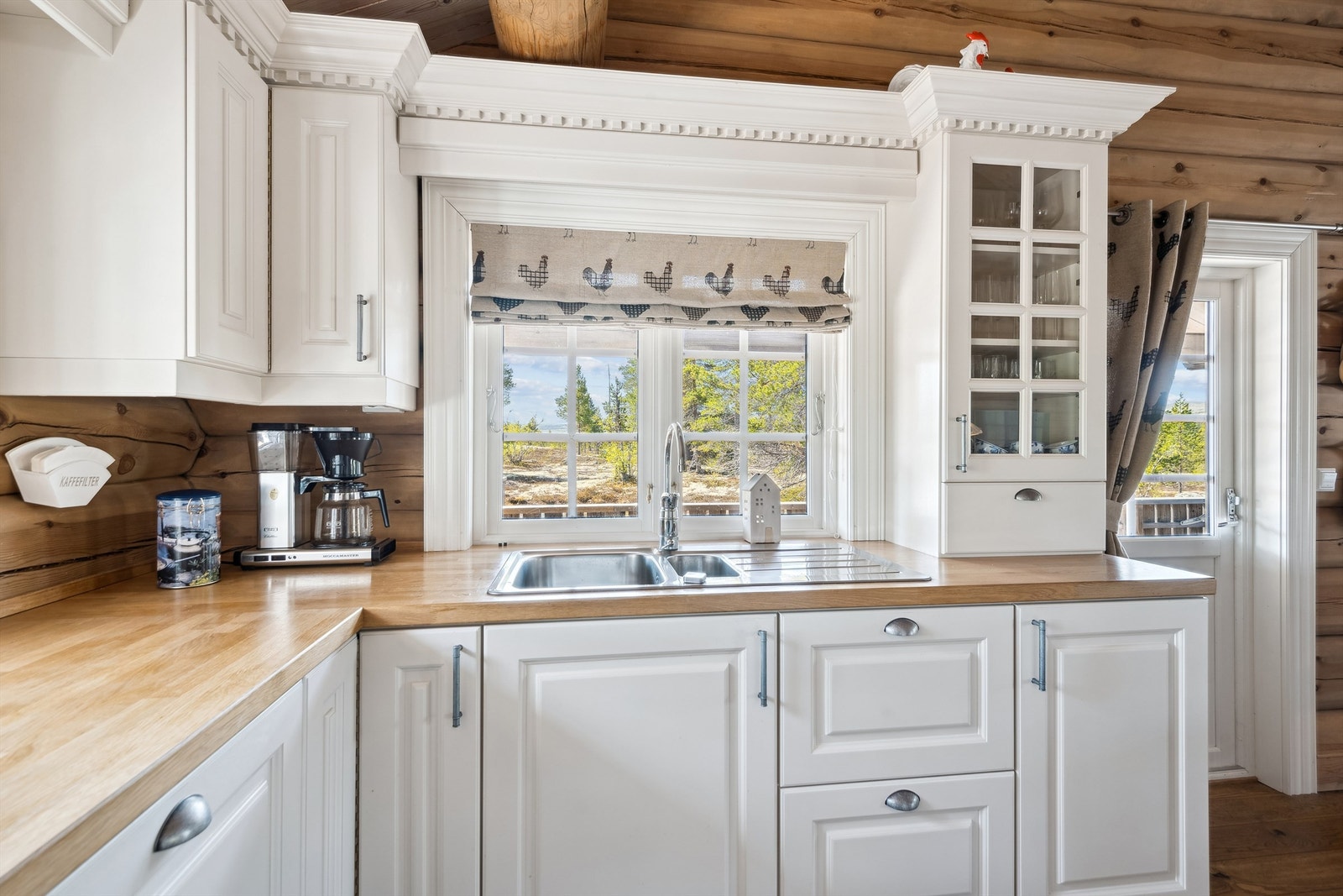 Kjøkken med vinduer på to sider samt utgang til terrasse Galleribilde