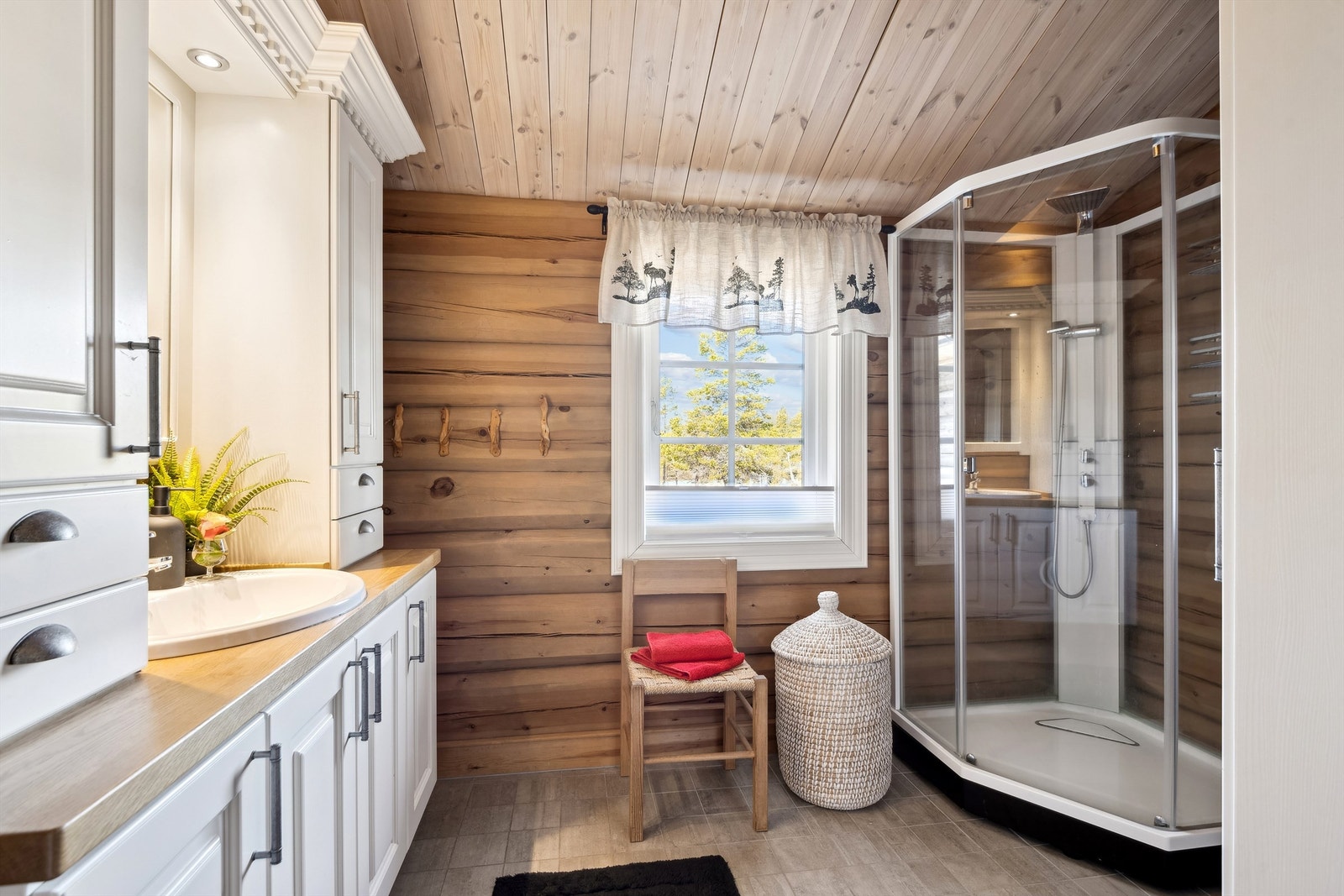 Badet har flislagt gulv med varmekabler. Dusjkabinett, WC og en fin og romslig innredning i god kvalitet Galleribilde