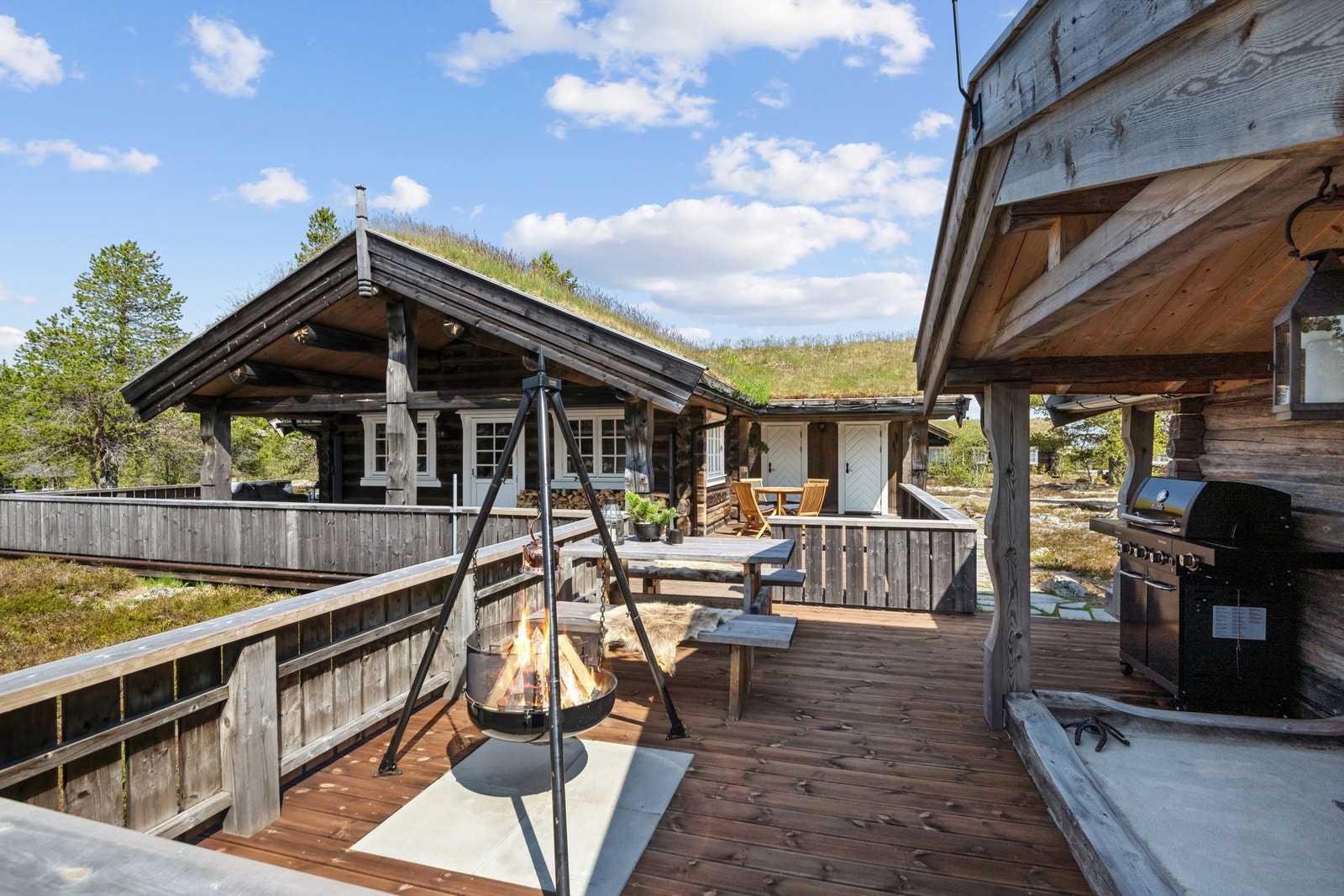 Det er en stor terrasse rundt tre sider av hytta som avsluttes med ei nydelig tømmerstue med en flott plass utenfor. Tømmerstua har ei koselig stue med glassdør ut til den murte grillen. Vedbod i del av bygget Galleribilde