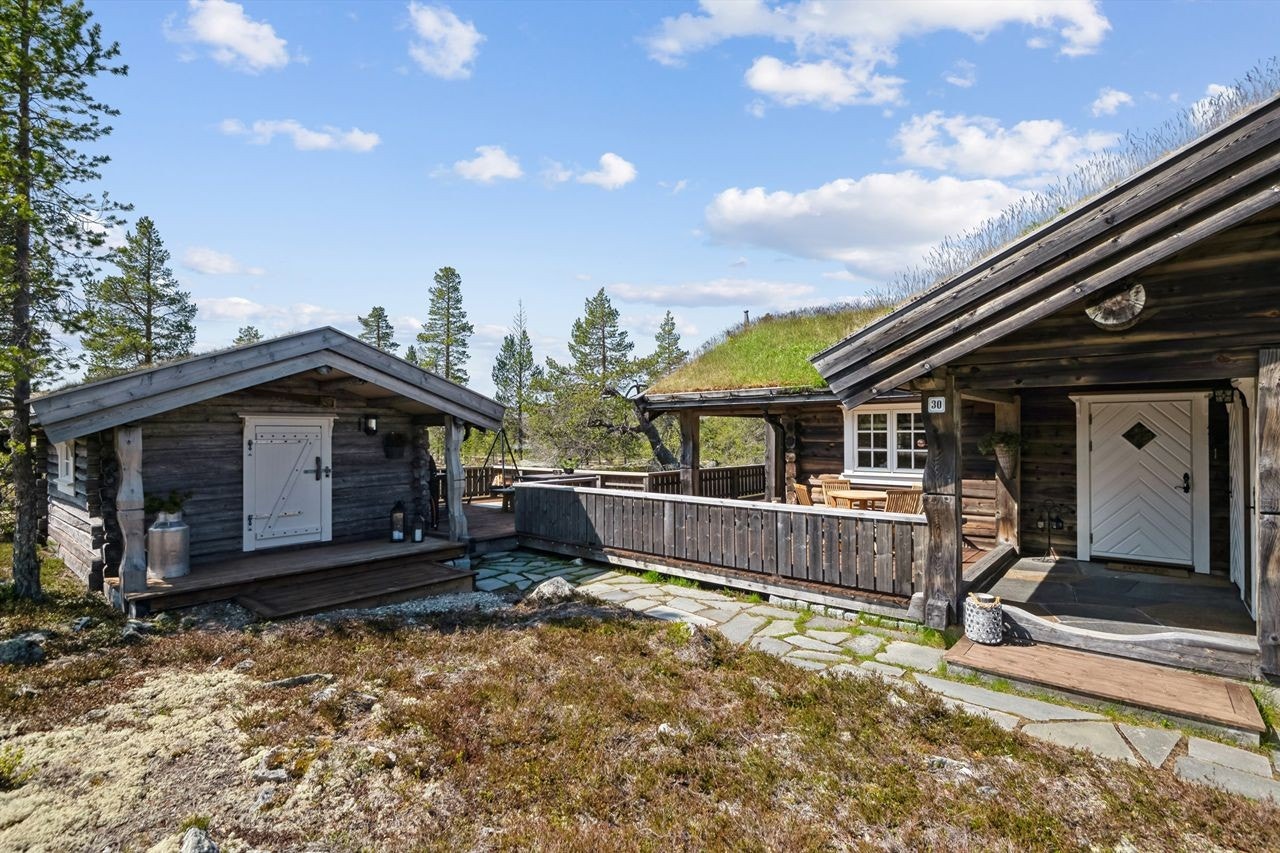 Hytta har overbygget inngangsparti med skiferheller på gulv Galleribilde