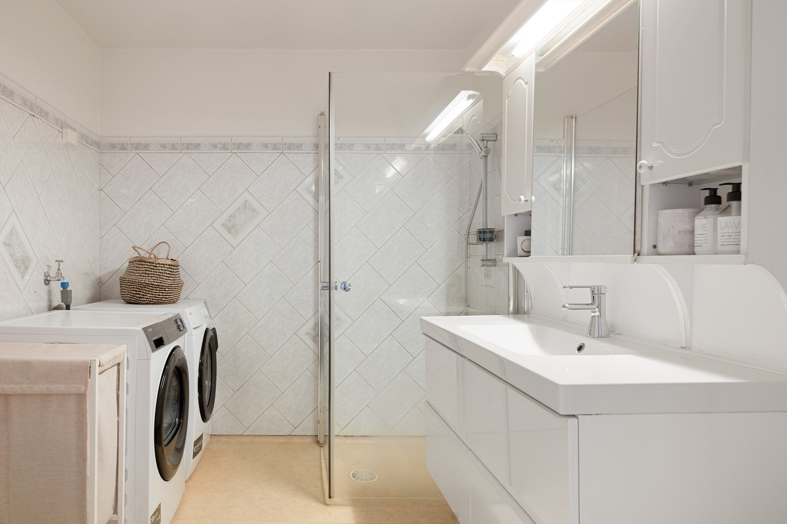 Badet har også praktisk dusjhjørne med innfellbare dusjdører, samt opplegg for vaskemaskin og tørketrommel Galleribilde