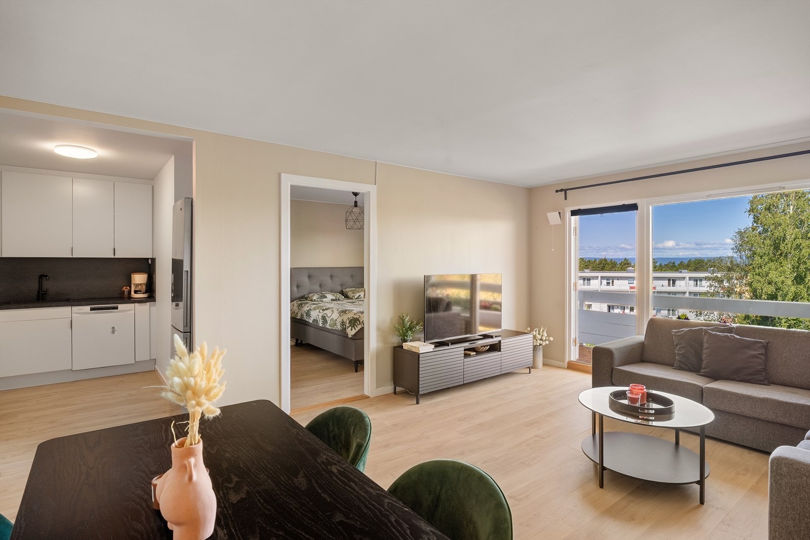 Leiligheten har en åpen stue- og kjøkkenløsning som gir en sosial og hyggelig atmosfære Galleribilde