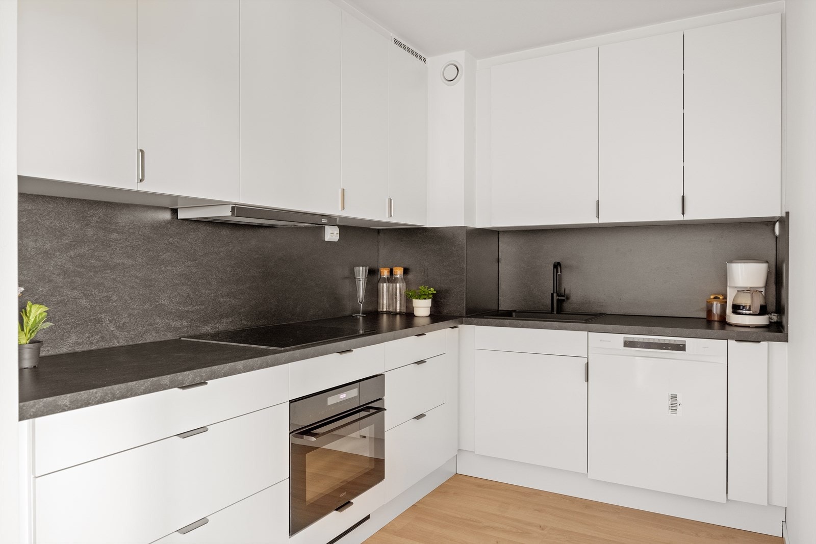 Kjøkkenet har integrerte hvitevarer som stekeovn og platetopp, ellers frittstående oppvaskmaskin og kjøl/fryseskap Galleribilde