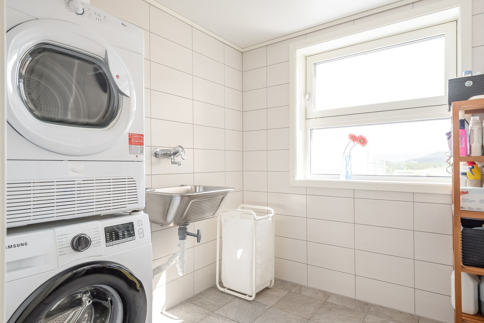 Praktisk vaskerom i tilknytning til badet, innredet med opplegg for vaskemaskin og tørketrommel. Galleribilde