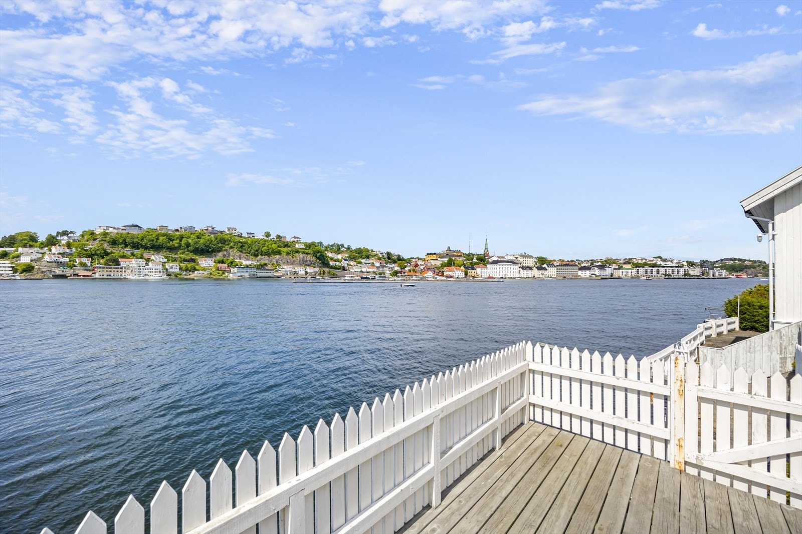 Praktfull beliggenhet helt i vannkanten med vel 25 meter strandlinje, brygger og bryggeterrasser mot indre byfjord. Galleribilde