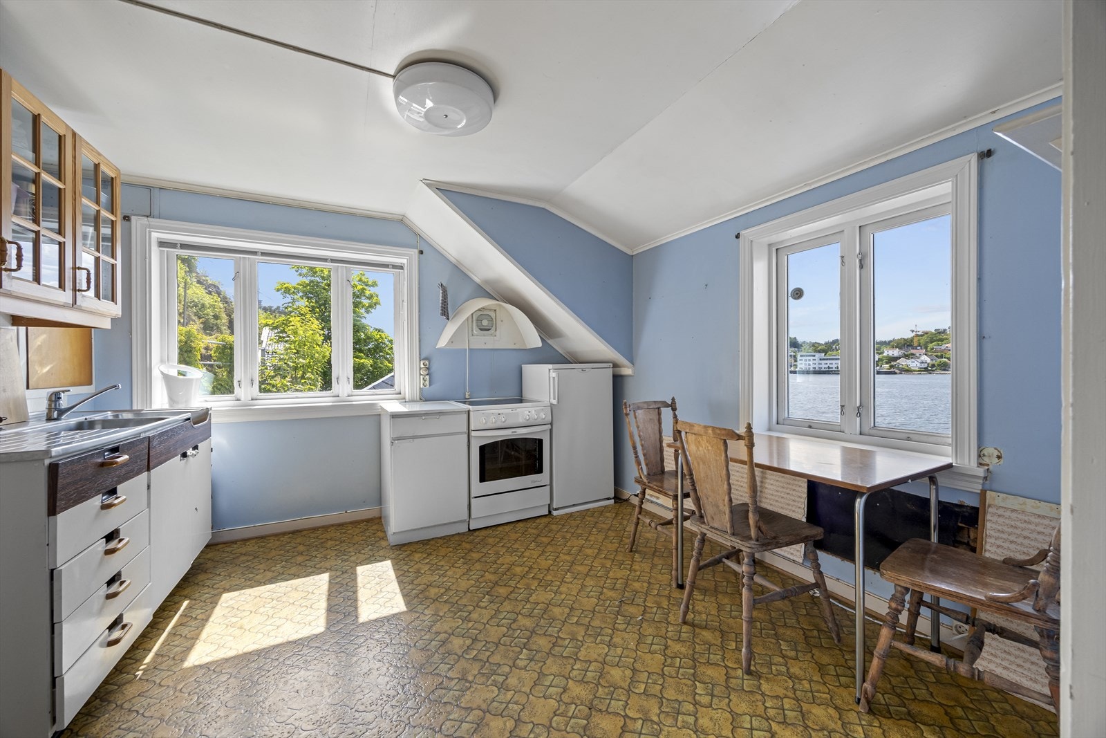 Eldre kjøkken med plassbygget innredning. Galleribilde