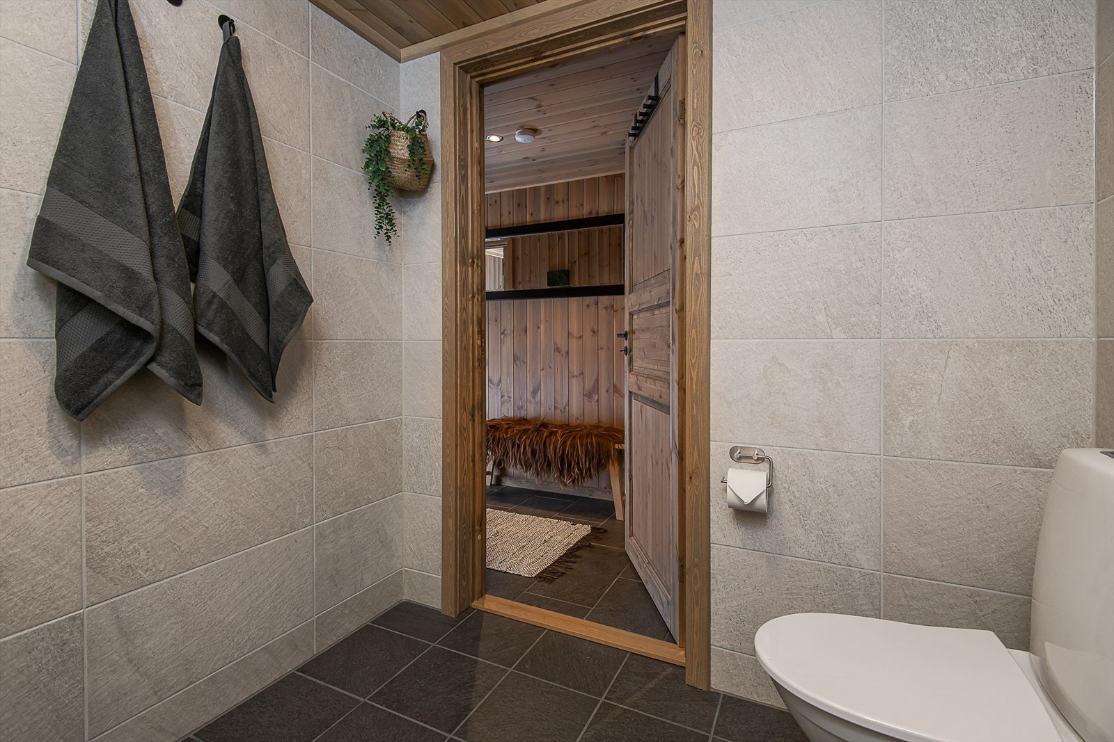 Badet har fliser på vegger og gulv i nøytrale og tidløse fargetoner. Galleribilde