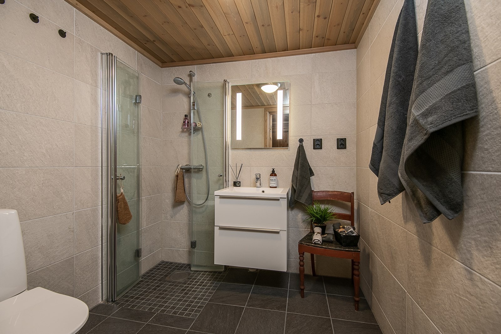 Pent og stilrent bad med dusjhjørne, servantinnredning og WC. Galleribilde