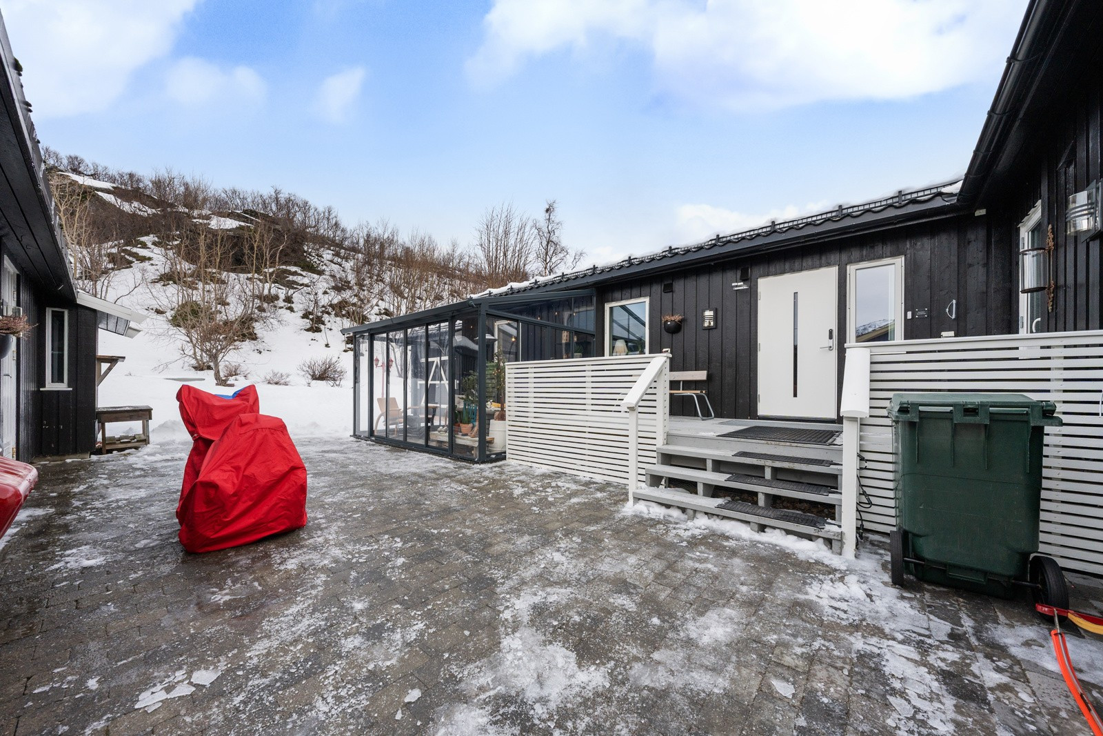 Belegningsstein og skiferheller gir et pent opparbeidet uteområde.