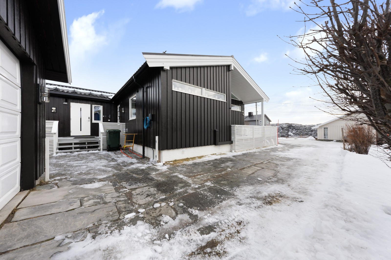 Store utearealer med steinbelagt innkjørsel.