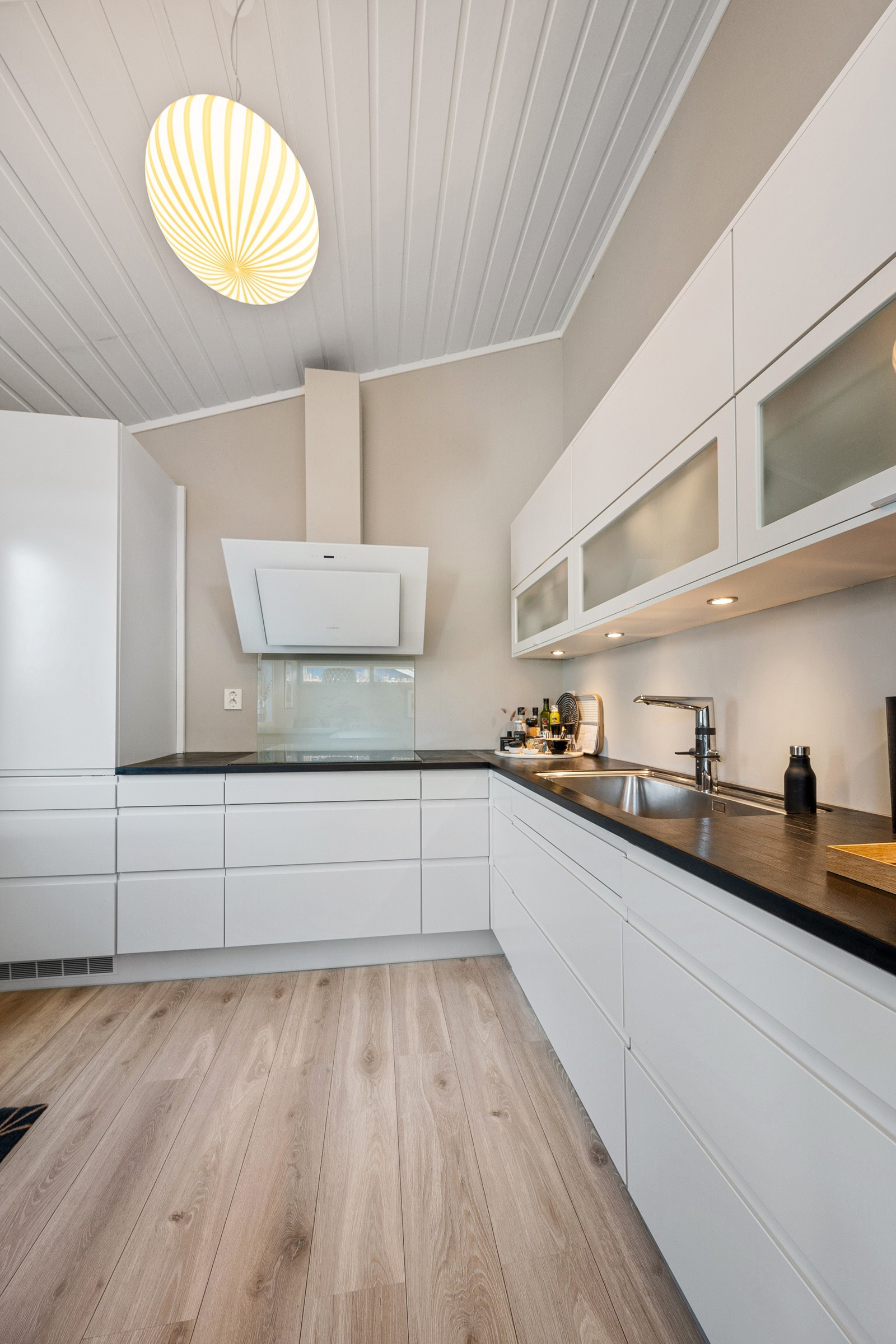 Lyst og moderne kjøkken med innredning fra HTH og benkeplate i heltre eik.