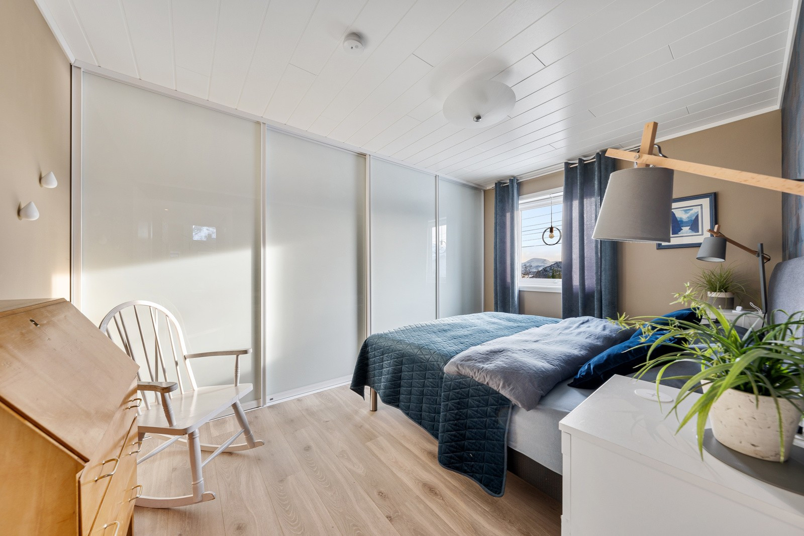 Romslig hovedsoverom med skyvedørsgarderobe fra Leba.