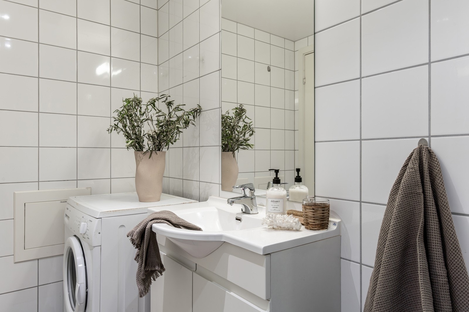 Stort flislagt bad med opplegg til vaskemaskin og tørketrommel. Galleribilde