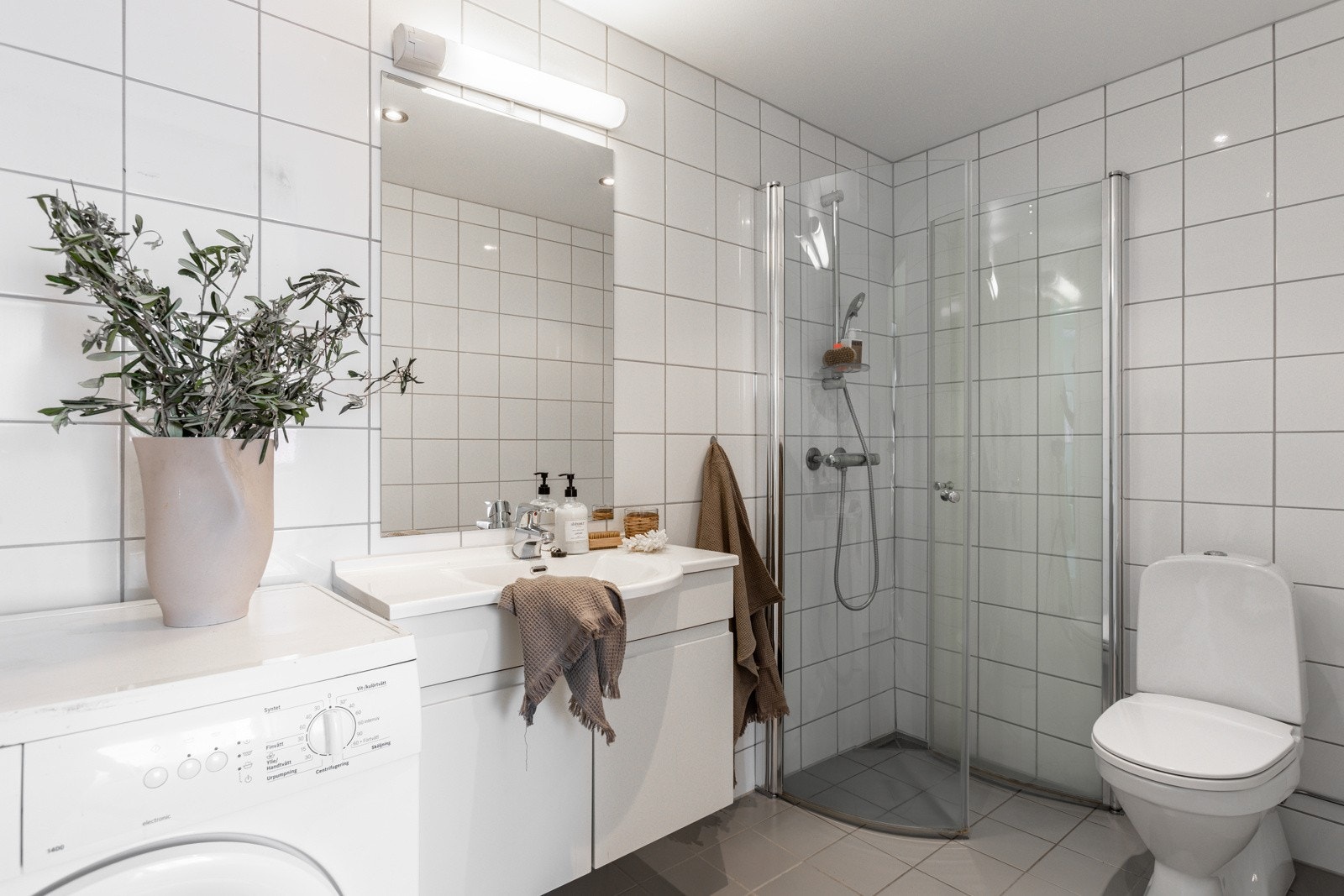 Flislagt bad som er stilrent og delikat, med fliser i lyse, nøytrale toner som gir rommet et rent og elegant uttrykk. Gulvvarme under flisene gir ekstra komfort - særlig på kalde morgener. Galleribilde