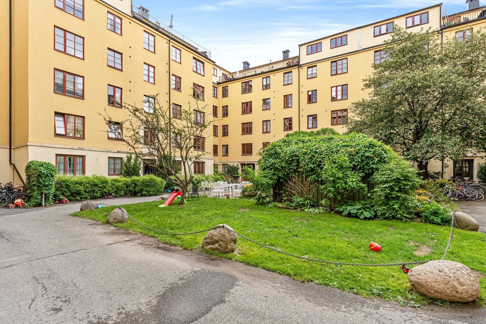 Sameiet har en barnevennlig og frodig bakgård med plen, beplanting og sittegrupper Galleribilde