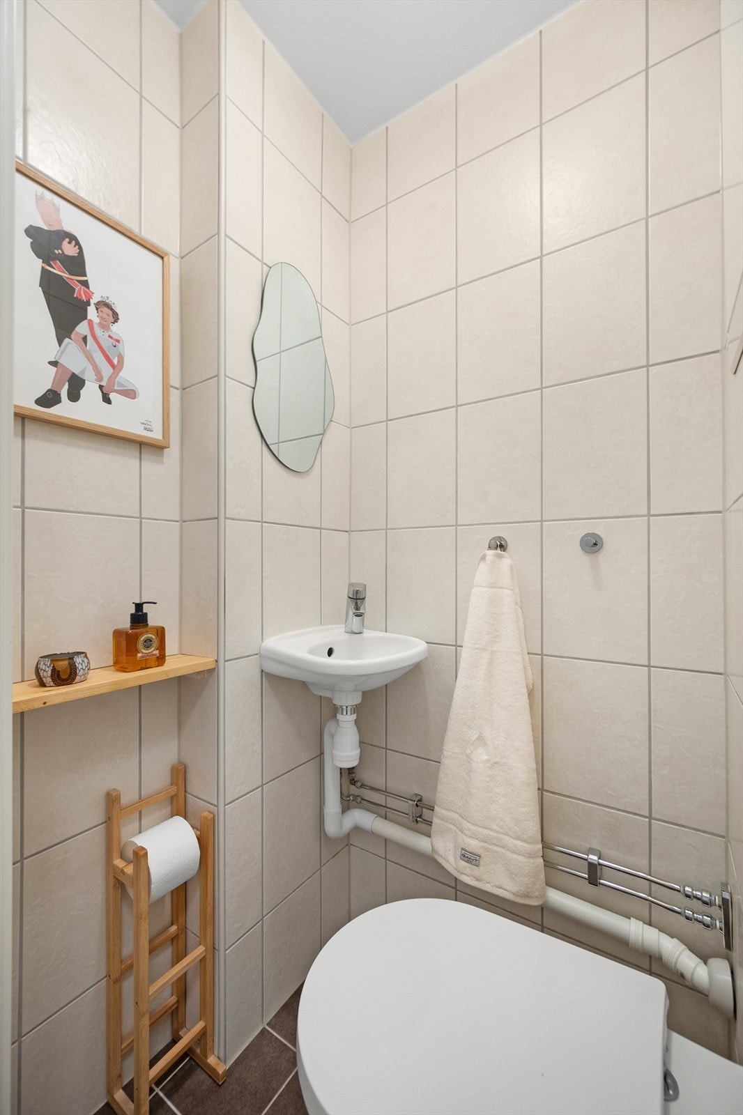 Praktisk, separat toalett bestående av toalett, servant og speil på vegg. Galleribilde