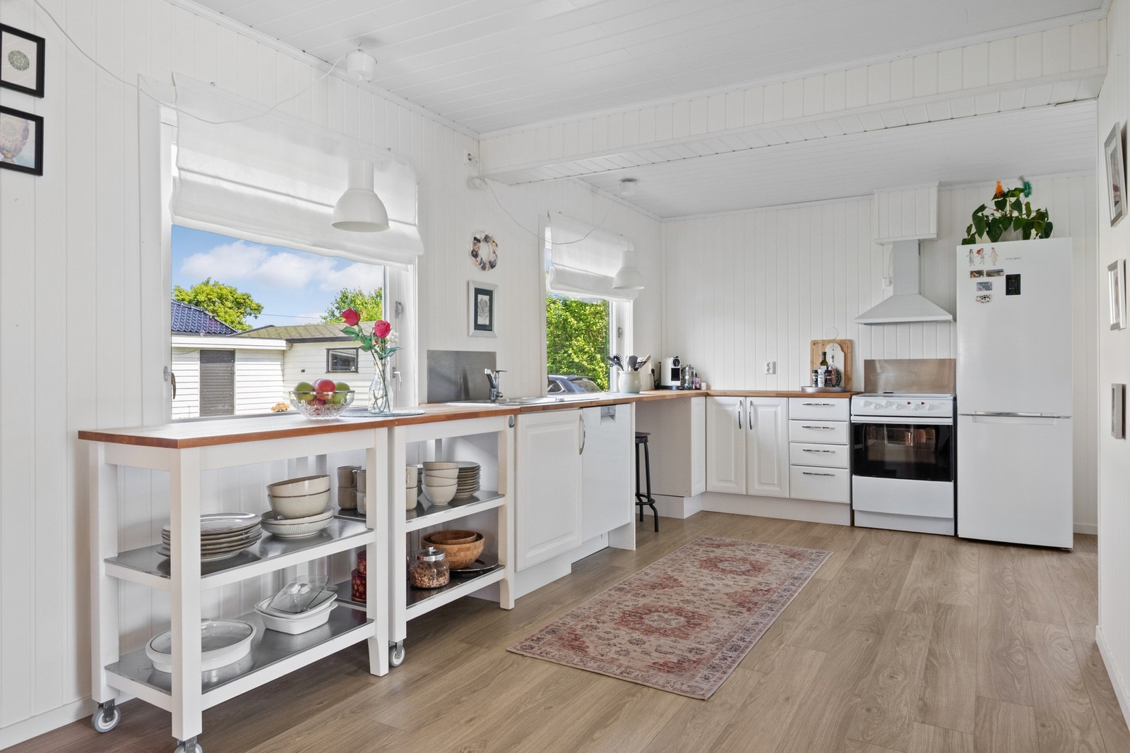 Innredningen har hvite, profilerte fronter og gyllen heltrebenkeplate med nedfelt kum i stål. Galleribilde