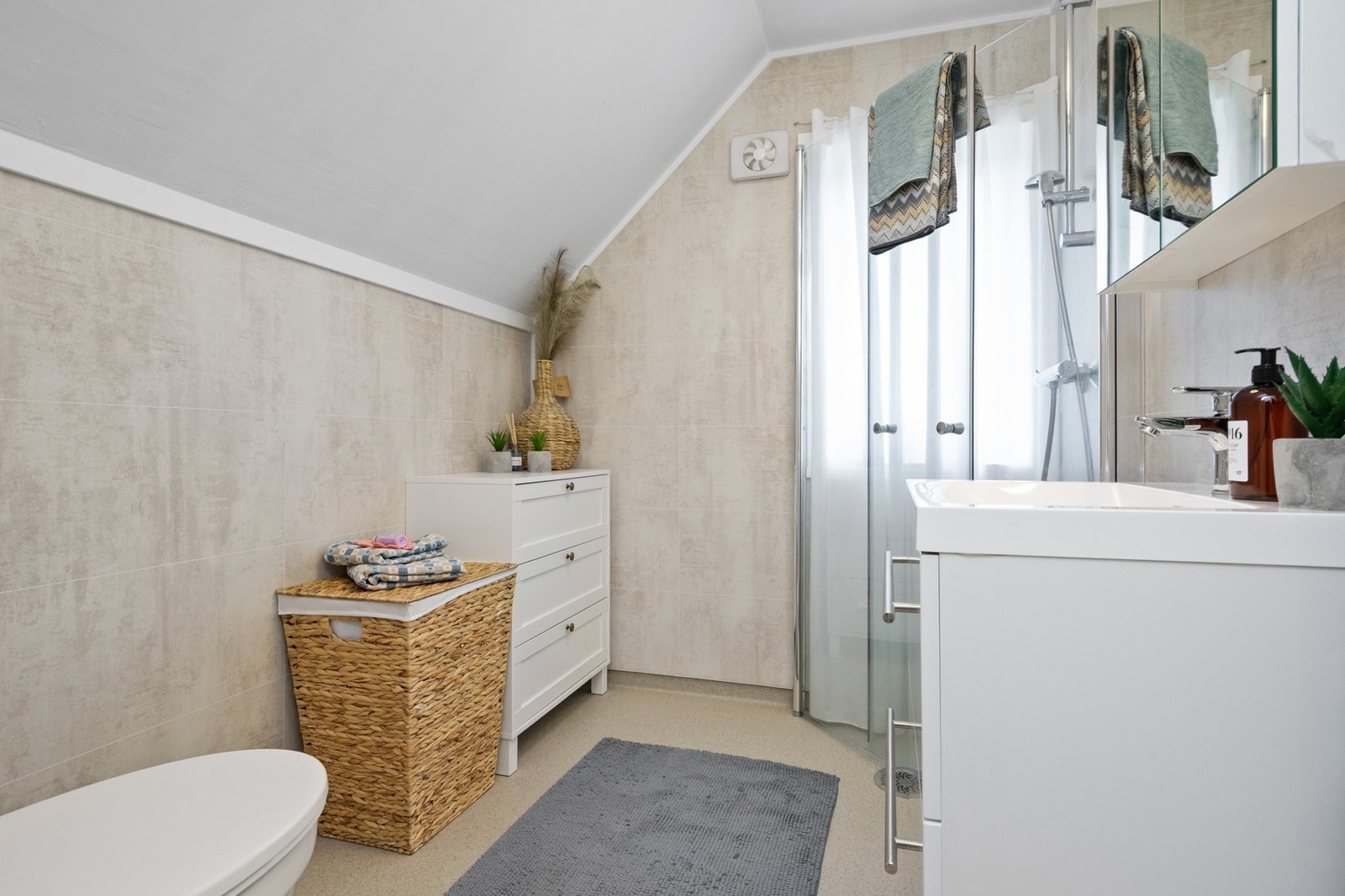 Badet ligger ved soverommene i andre etasje, og har lyse våtromsplater på veggene og matchende belegg på gulv med gulvvarme. Galleribilde