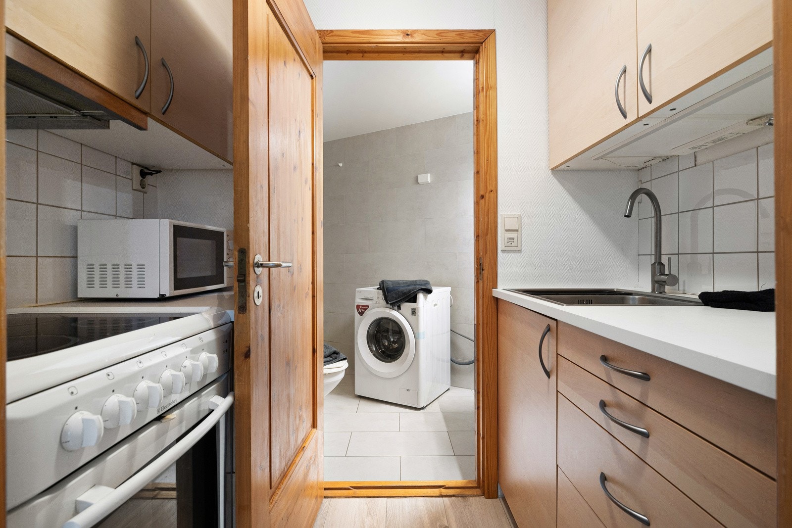 Hybel - Funksjonelt kjøkken med innredning av finérte eller laminerte fronter og en laminert benkeplate med nedfelt stålkum. Galleribilde