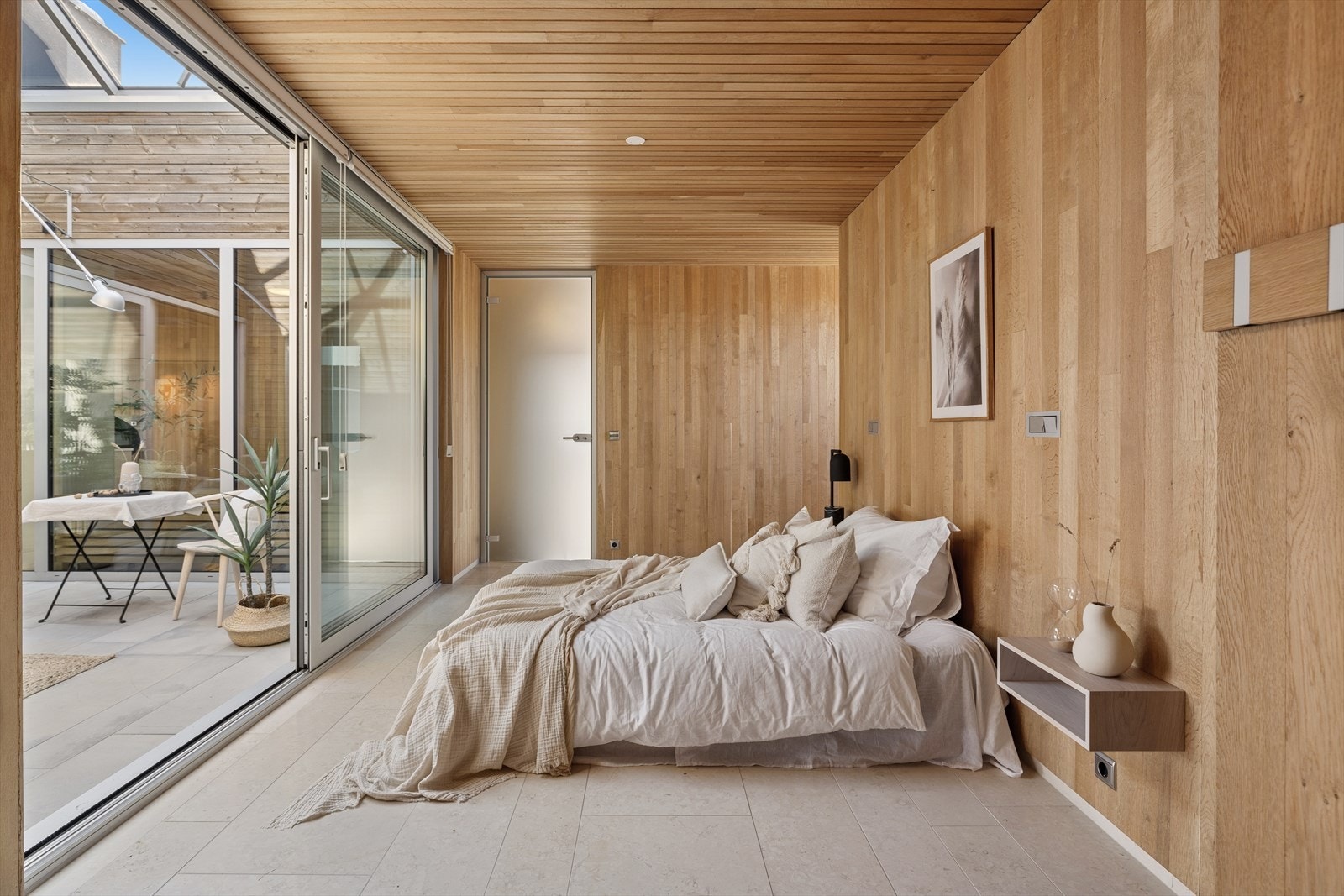 Soverom med store skyvedører i glass åpner opp mot atriet og slipper inn godt med dagslys. Galleribilde