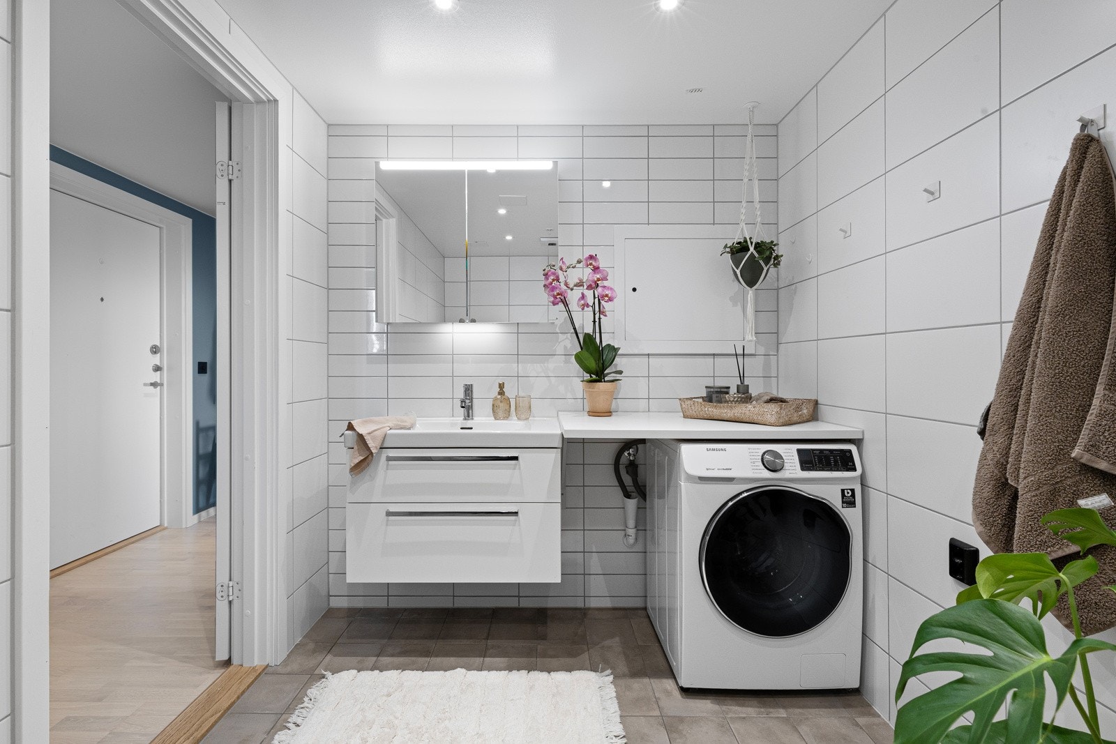 Moderne og pent baderom med varmekabler i gulv og opplegg for vaskemaskin. Galleribilde