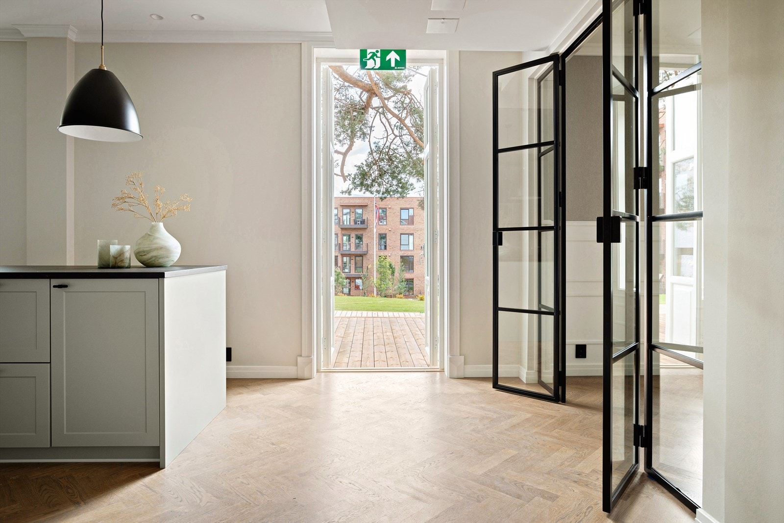 Fra kjøkkenet i hagevillaen er det utgang til en stor platting med videre adkomst til den frodige hage Galleribilde