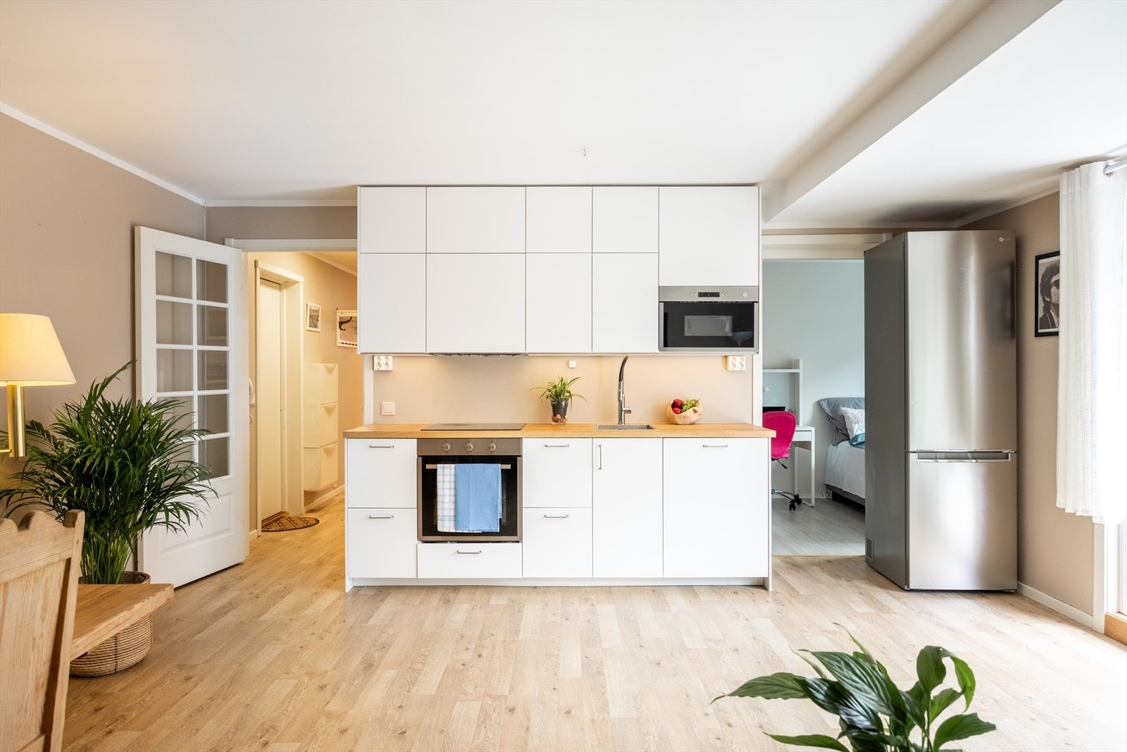 Stilrent IKEA-kjøkken fra 2023 med hvite, glatte fronter og laminat benkeplate. Galleribilde