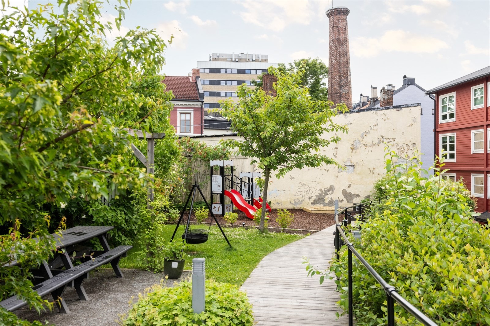 Indre gårdsrom er pent opparbeidet med beplatning, sittegrupper, bålpanne og lekeplass. Galleribilde