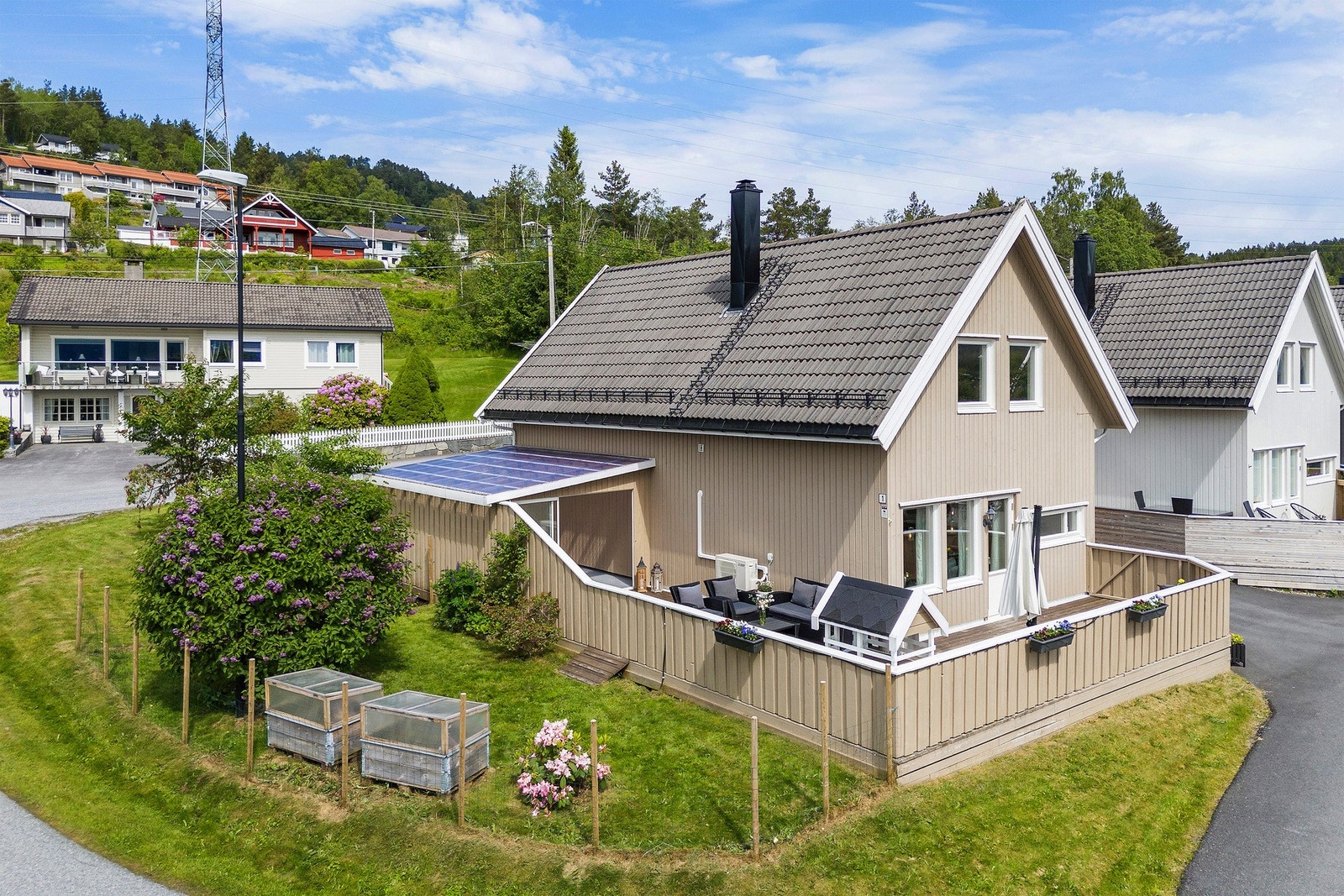 Lundbøen 1 ligger på hjørnetomt og med pen beplantning i hagen. Legg merke til snøfanger og stigtrinn til pipe. Galleribilde