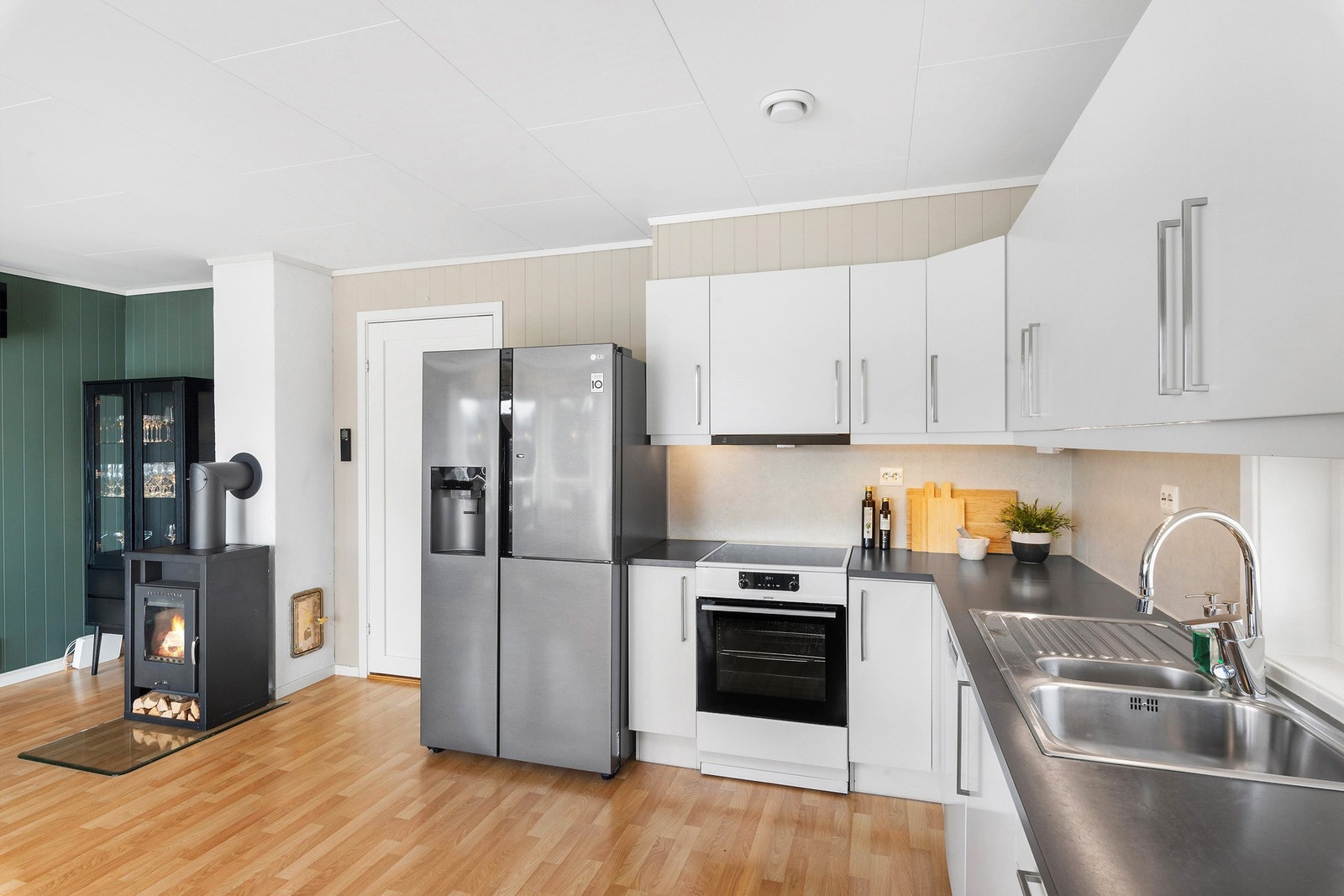 Kjøkken og stue har åpen løsning og boligen har både varmepumpe og ildsted. Galleribilde