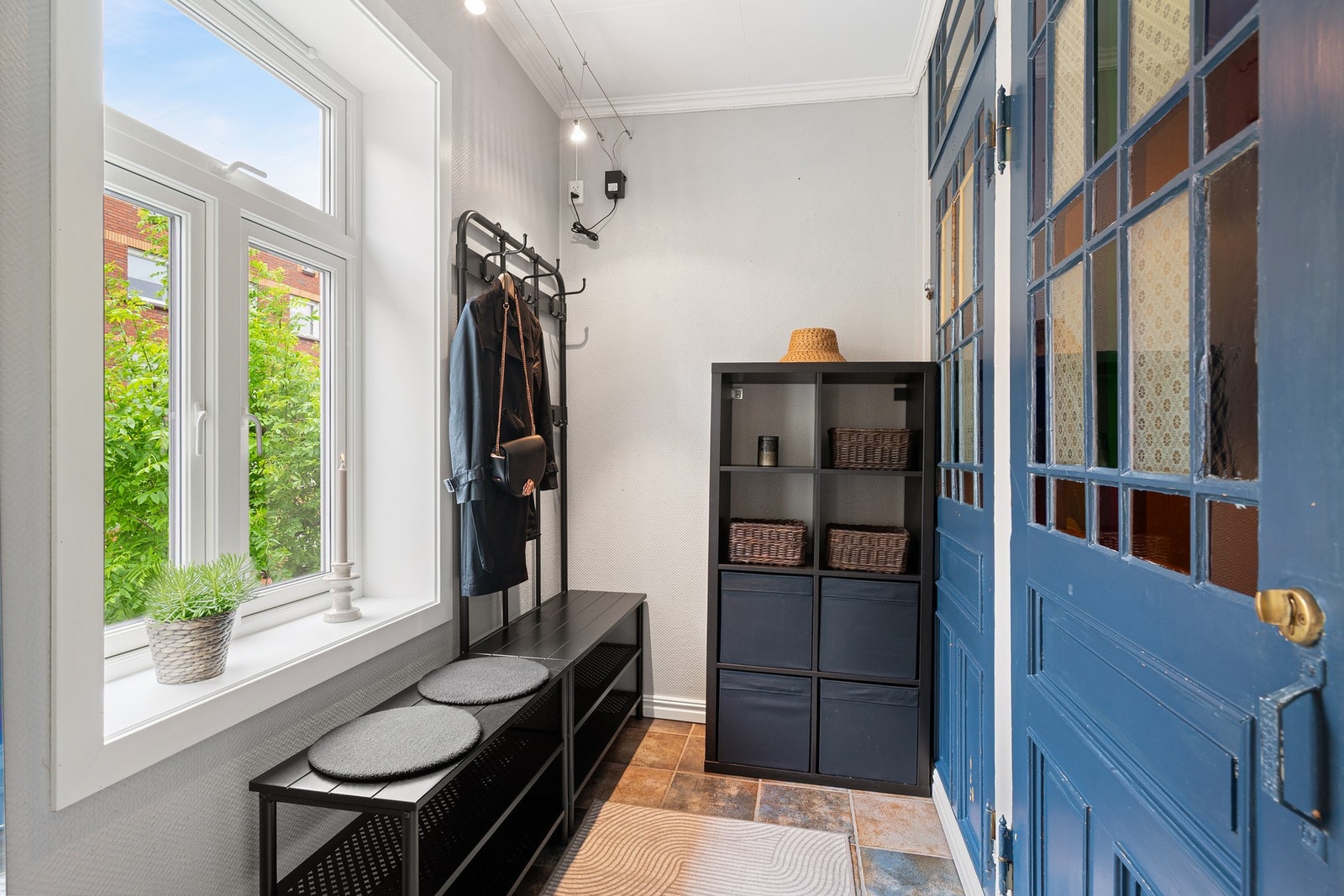 Entréen er lys og innbydende, med klassiske detaljer, flott vindu og praktiske oppbevaringsløsninger. Galleribilde