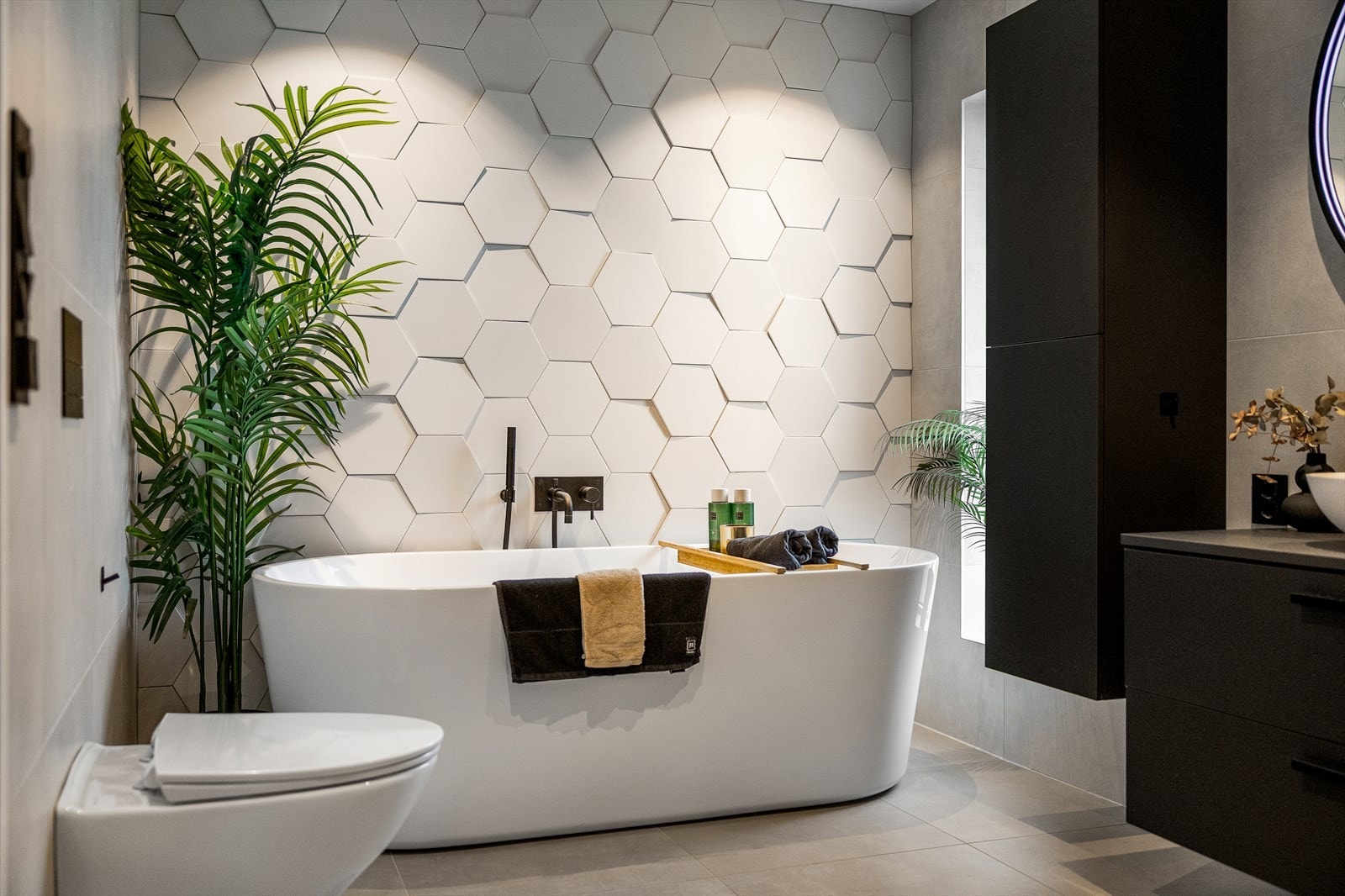 Rommet gir en gjennomført spa-følelse, med store grå gulvfliser fra Fagflis som gir et elegant og tidløst uttrykk, og en kontrastvegg i designfliser fra den spanske produsenten WOW som tilfører det lille ekstra. Galleribilde