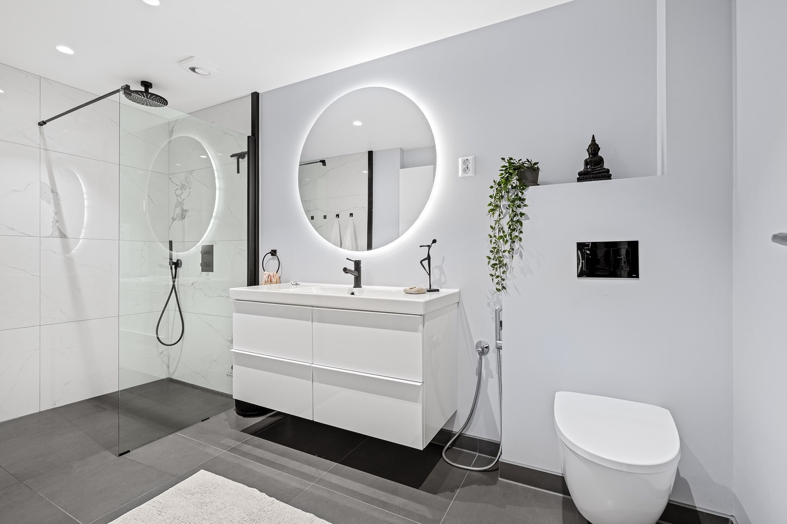 Badet er lekkert oppusset av fagfolk og var ferdig i 2020. Det har store tidsriktige 60x60 fliser på gulv og i dusjsonen. Det er valgt regndusj, vegghengt toalett med spyl, samt baderomsinnredning med speil over. Varmekabler i gulv, samt downlights i tak. Galleribilde