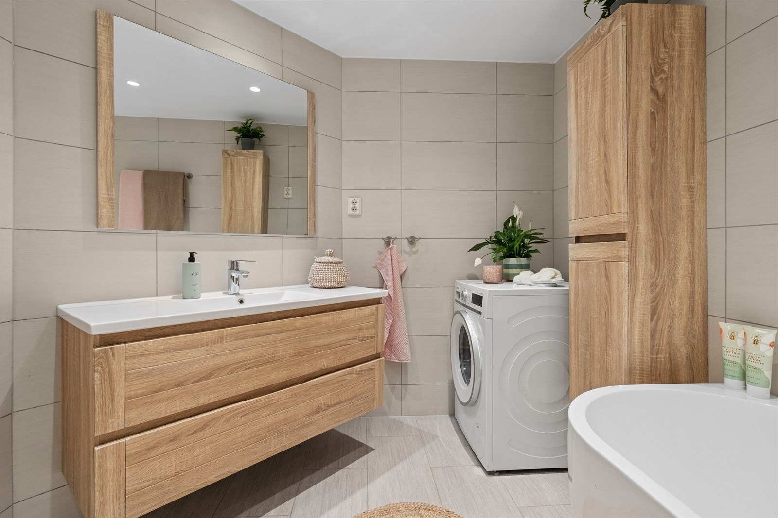 Moderne innredning og store sandfargede fliser gir badet et preg av luksus. Galleribilde