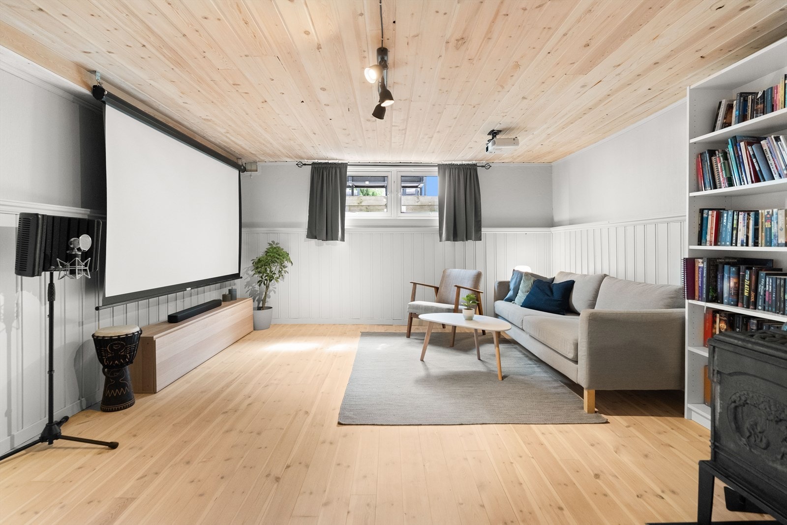 Rommet er møblert med sofa, tv-bord og bokhyller etc. Galleribilde