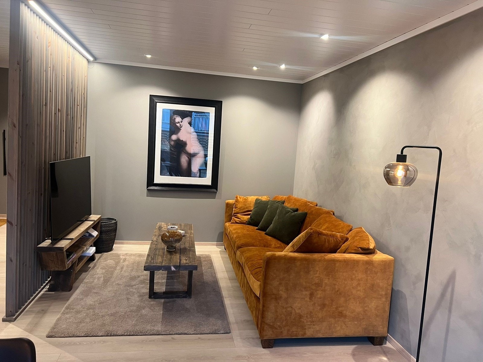 Fin sofakrok med en stilig spilevegg med lys og TV. Galleribilde
