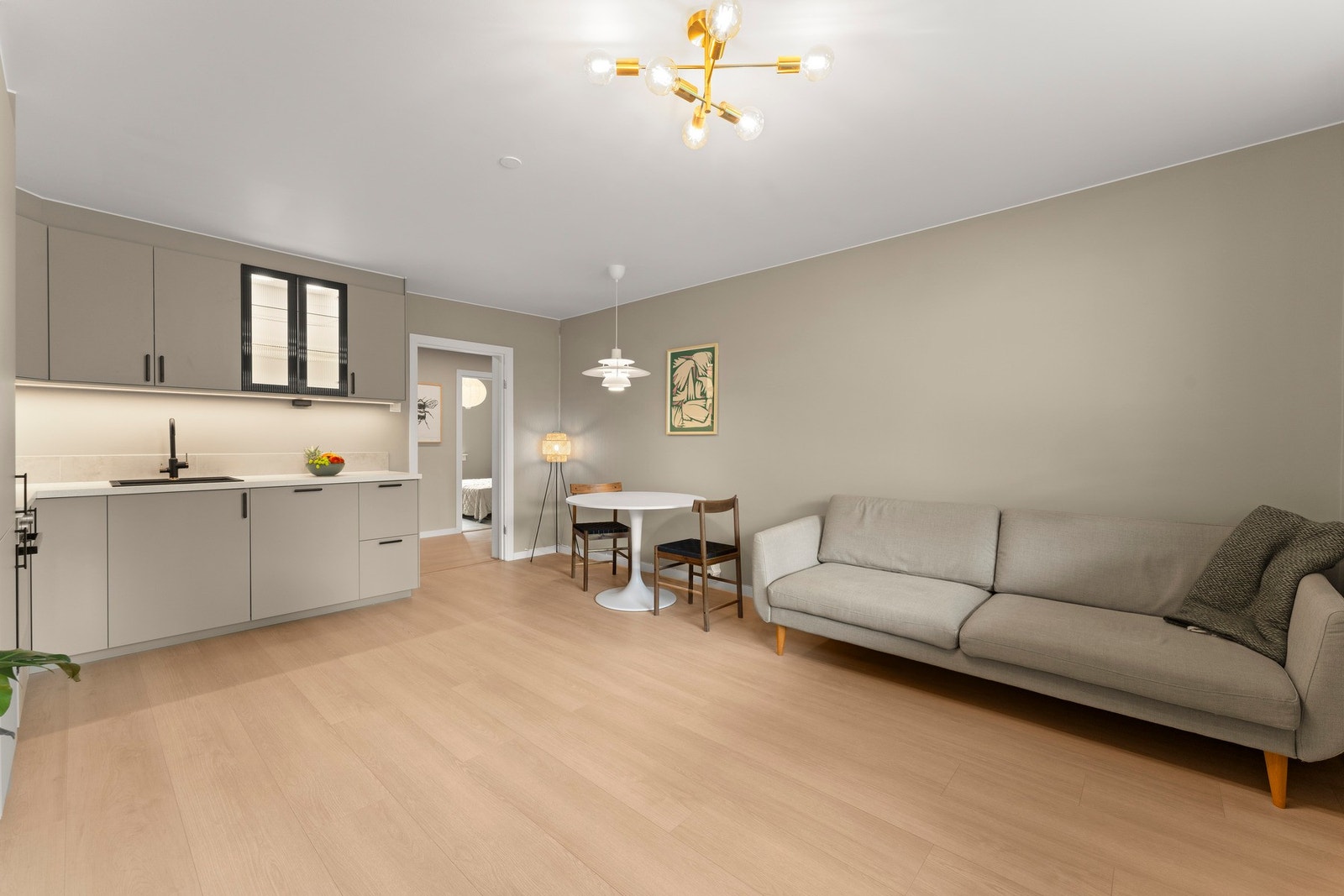 Over benken er det fliser og LED-lys under overskap. Det er integrert induksjonsplatetopp, stekeovn, oppvaskmaskin og kjøl/fryseskap. Galleribilde