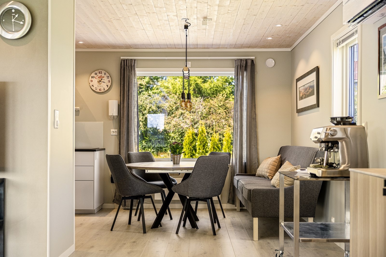 Mellom stue og kjøkken er det en koselig spiseplass som binder rommene naturlig sammen - et perfekt sted for både hverdagsmåltider og hyggelige middager med gjester. Galleribilde