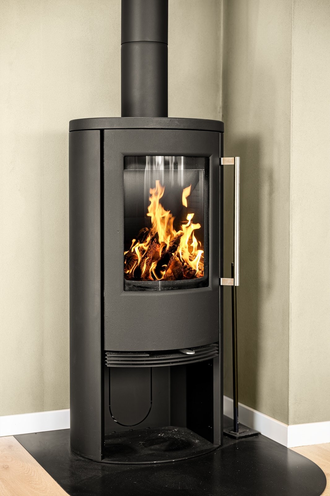 Den flotte peisovnen gir både varme og stemning på kjølige dager, mens varmepumpen sikrer en jevn og energieffektiv oppvarming gjennom hele året. Galleribilde