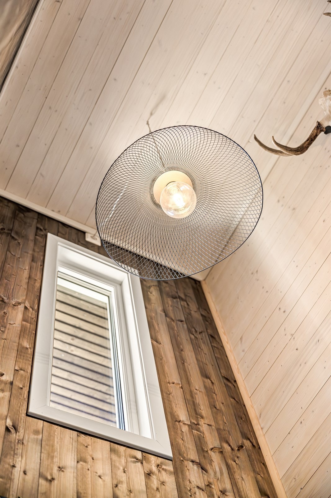 Pent trappeparti ned til underetasjen med lune, gjennomførte vegger i stilfullt trepanel - gir en varm og innbydende overgang mellom etasjene. Galleribilde