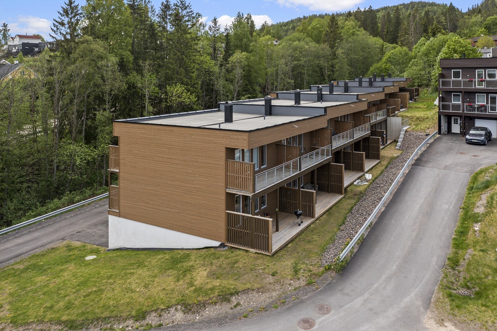 Stor terrasse på mark med en liten hage flekk uten for. Gresset blir fellesareal. Galleribilde