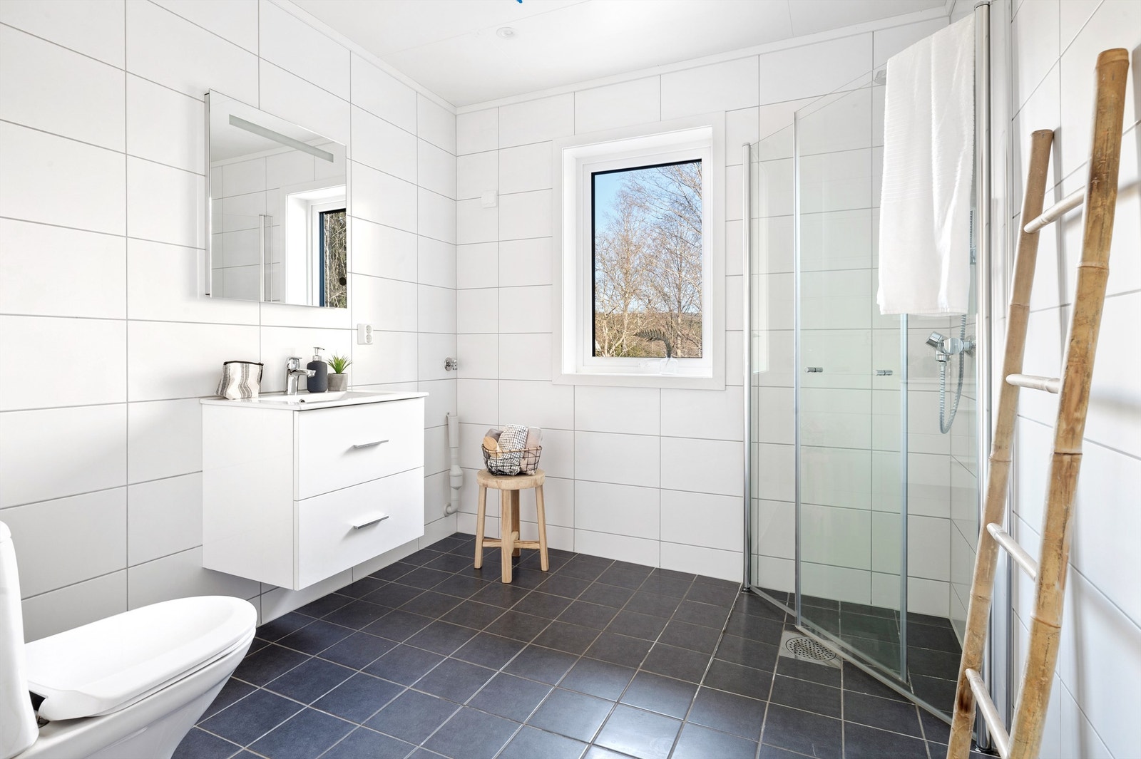 Badet i 1 etasje er innredet med dusjhjørne, vask, opplegg vaskemaskin og wc Galleribilde