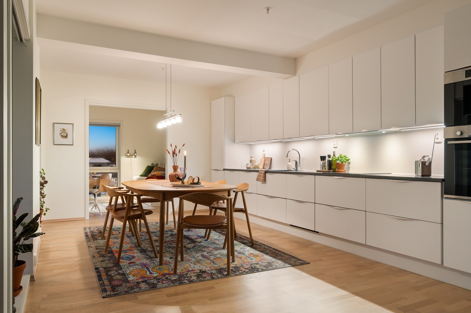 Pent tidløst kjøkken fra JKE-design med lyse slette fronter og benkeplate i kontrast. Galleribilde