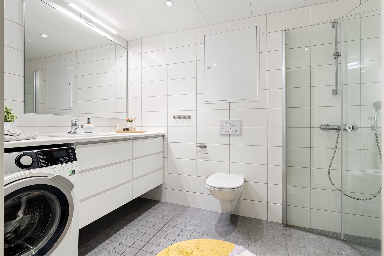 Pent flislagt bad med varme i gulv, downlights i himling og vegghengt toalett. Galleribilde