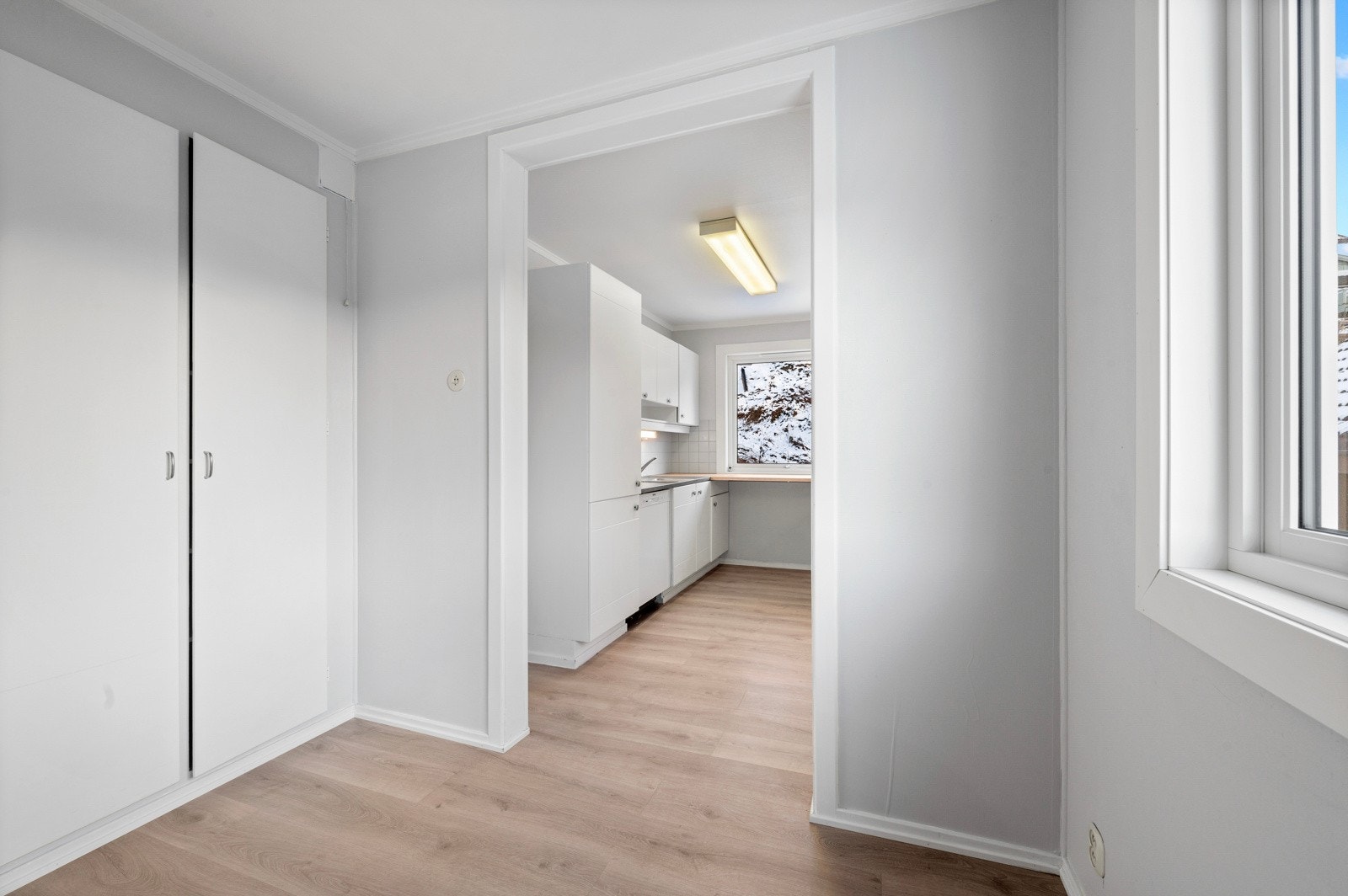 Rom mellom spisestue og kjøkken, med integrerte skaper. Galleribilde