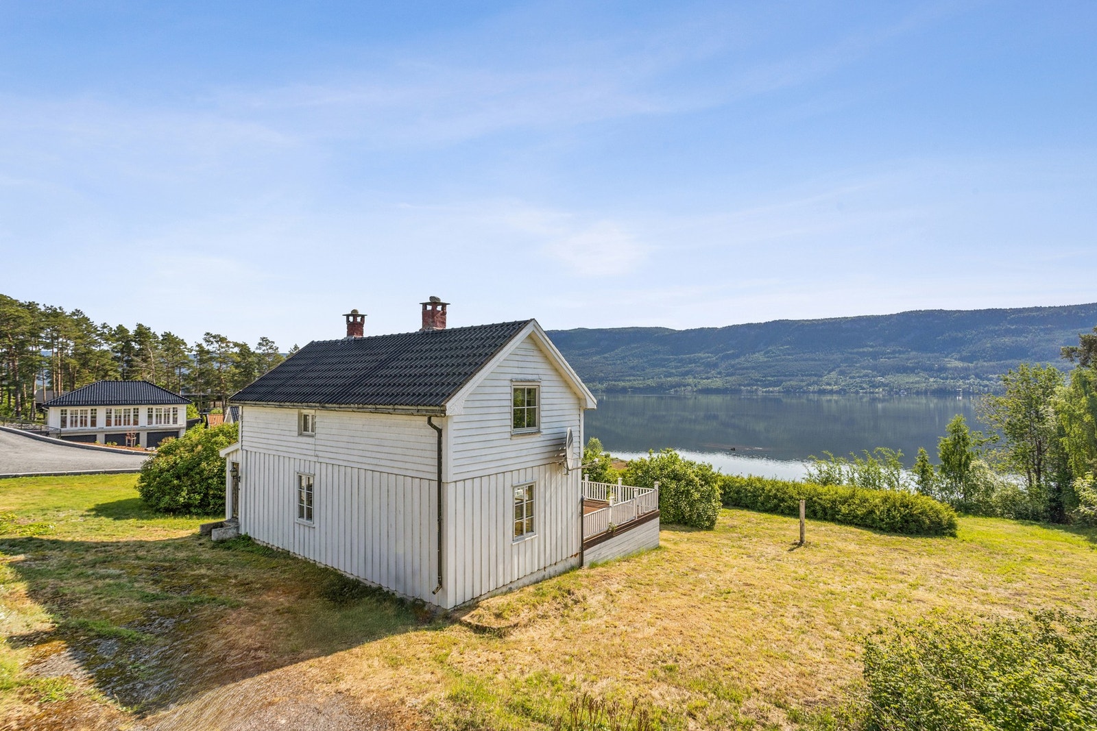 Tomten er romslig og skråner lett ned mot fjorden (egen strandlinje), noe som gir både utsikt og et luftig inntrykk. Galleribilde