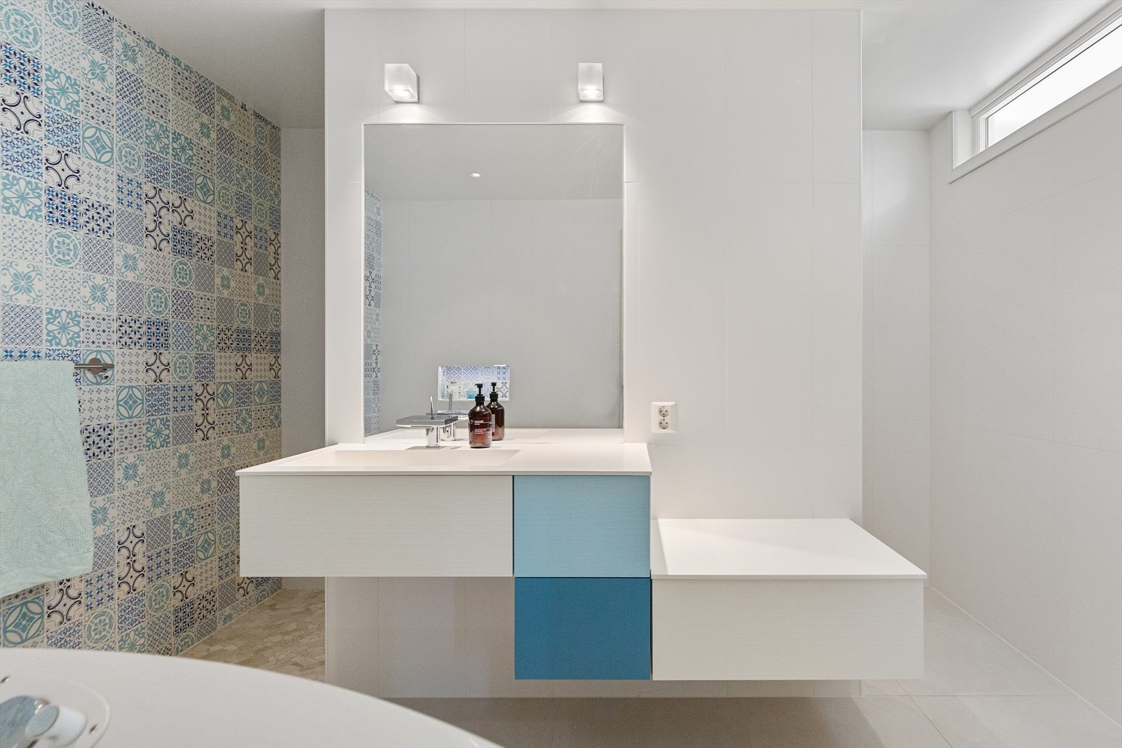 Delikat velværebad på hovedplan med hjørnekar, romslig dusjsone og lekre flisvalg. Galleribilde