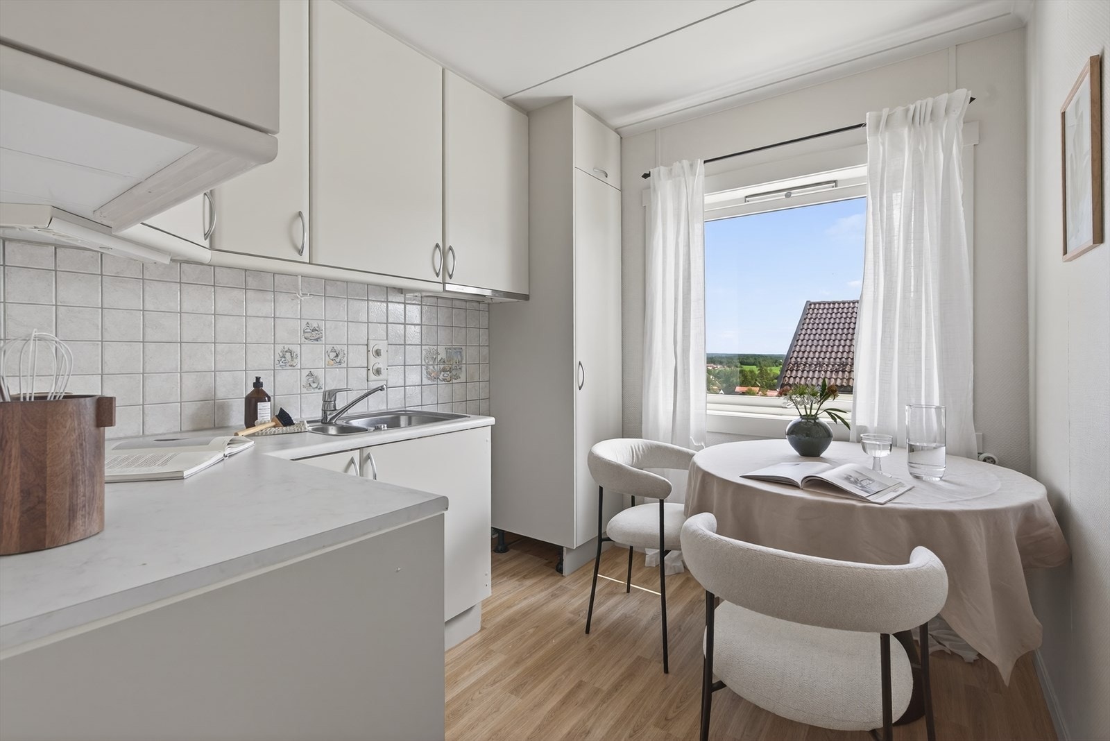 Kjøkken med slette fronter og laminat benkelate. Det er også plass til et spisebord på kjøkkenet Galleribilde