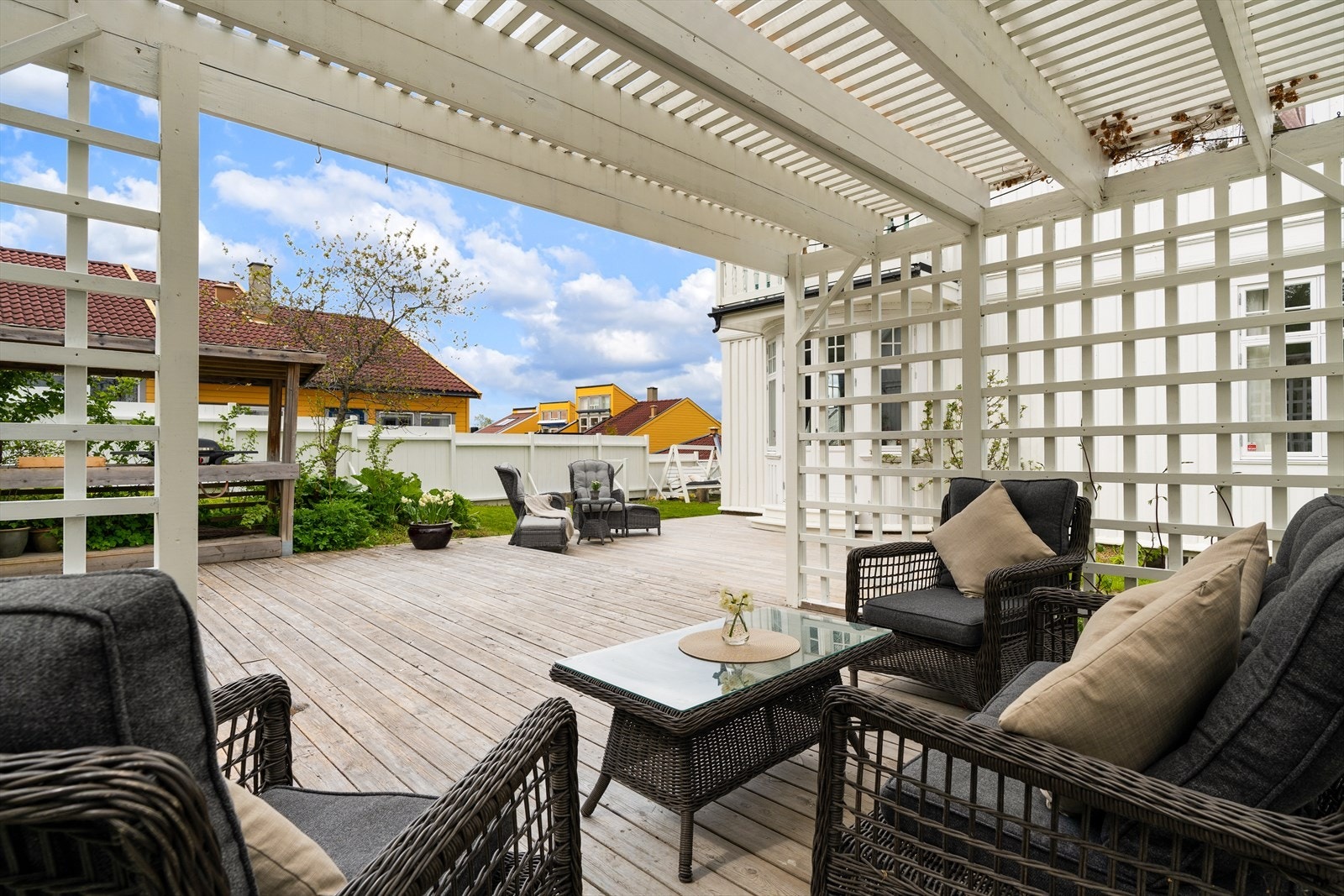 Flere plattinger, nivå, takoverbygg og pergola i hagen. Galleribilde